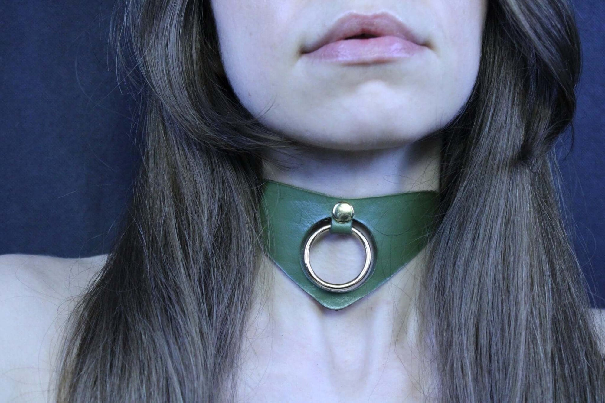 Olive green posture collar with bold O-ring, perfect for submissive jewelry and bondage aesthetics.