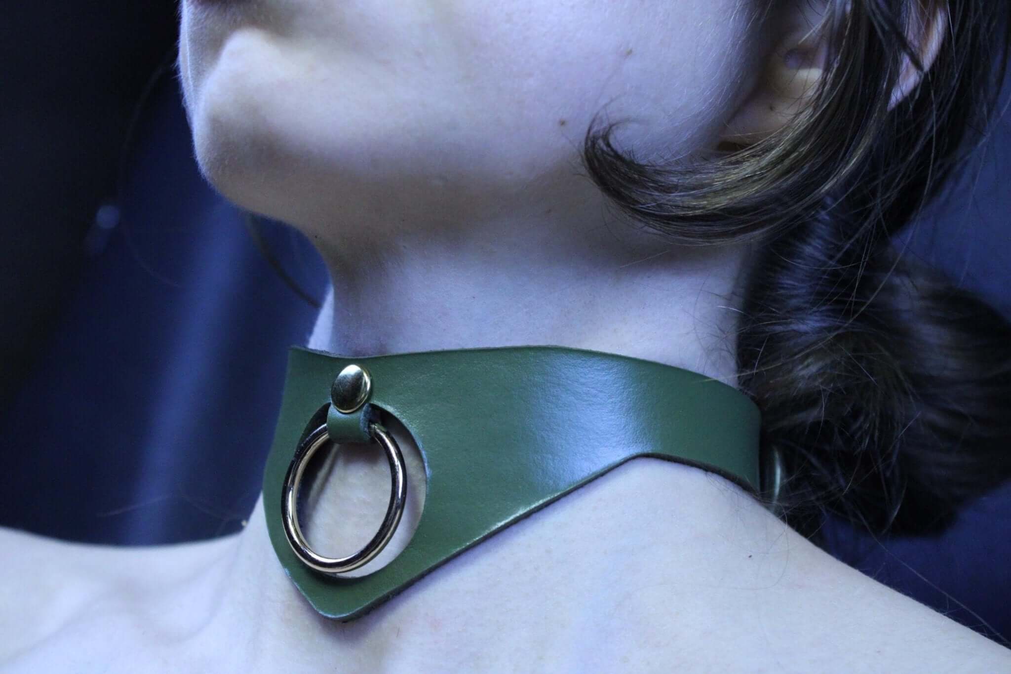 Olive green submissive collar with bold O-ring, ideal for BDSM, posture support, and elegant day wear.