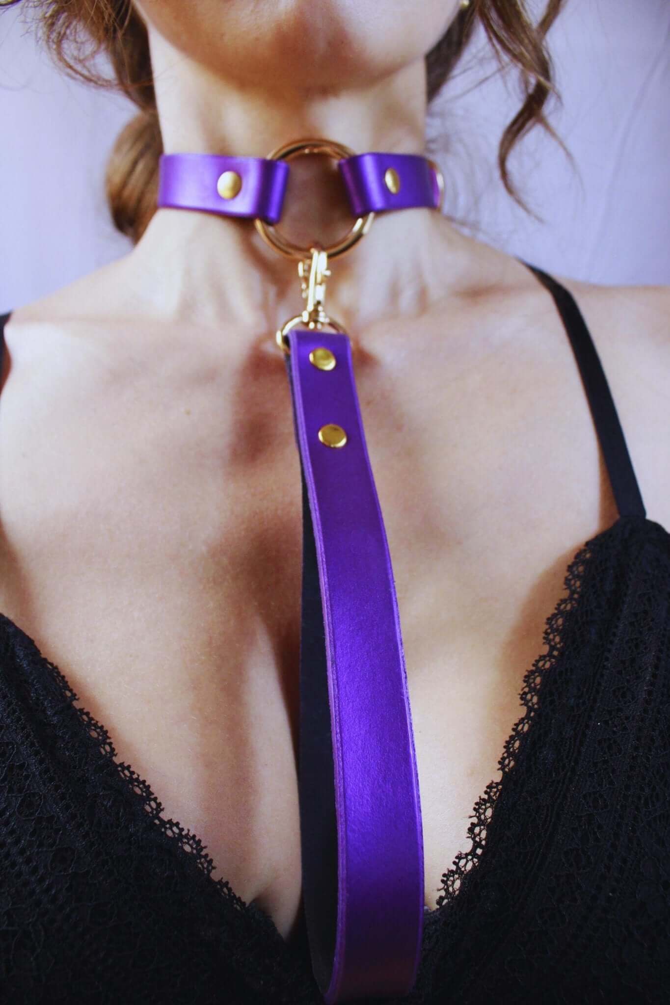 Elegant purple leather choker collar with gold accents, perfect for bondage and submissive jewelry styles.