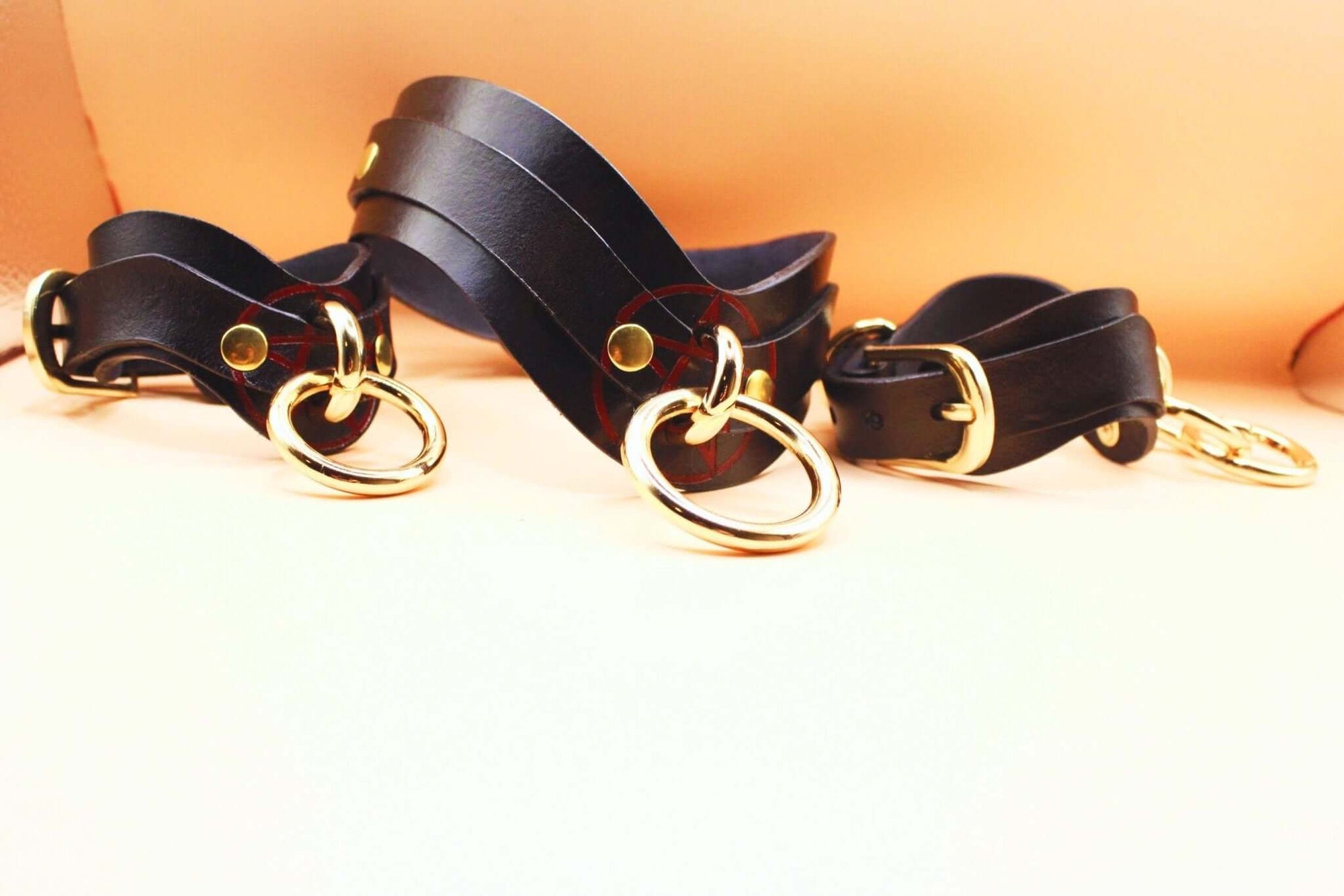 Pentagram BDSM collar set featuring leather straps and gold rings, ideal for bondage and submissive play in erotic lingerie.