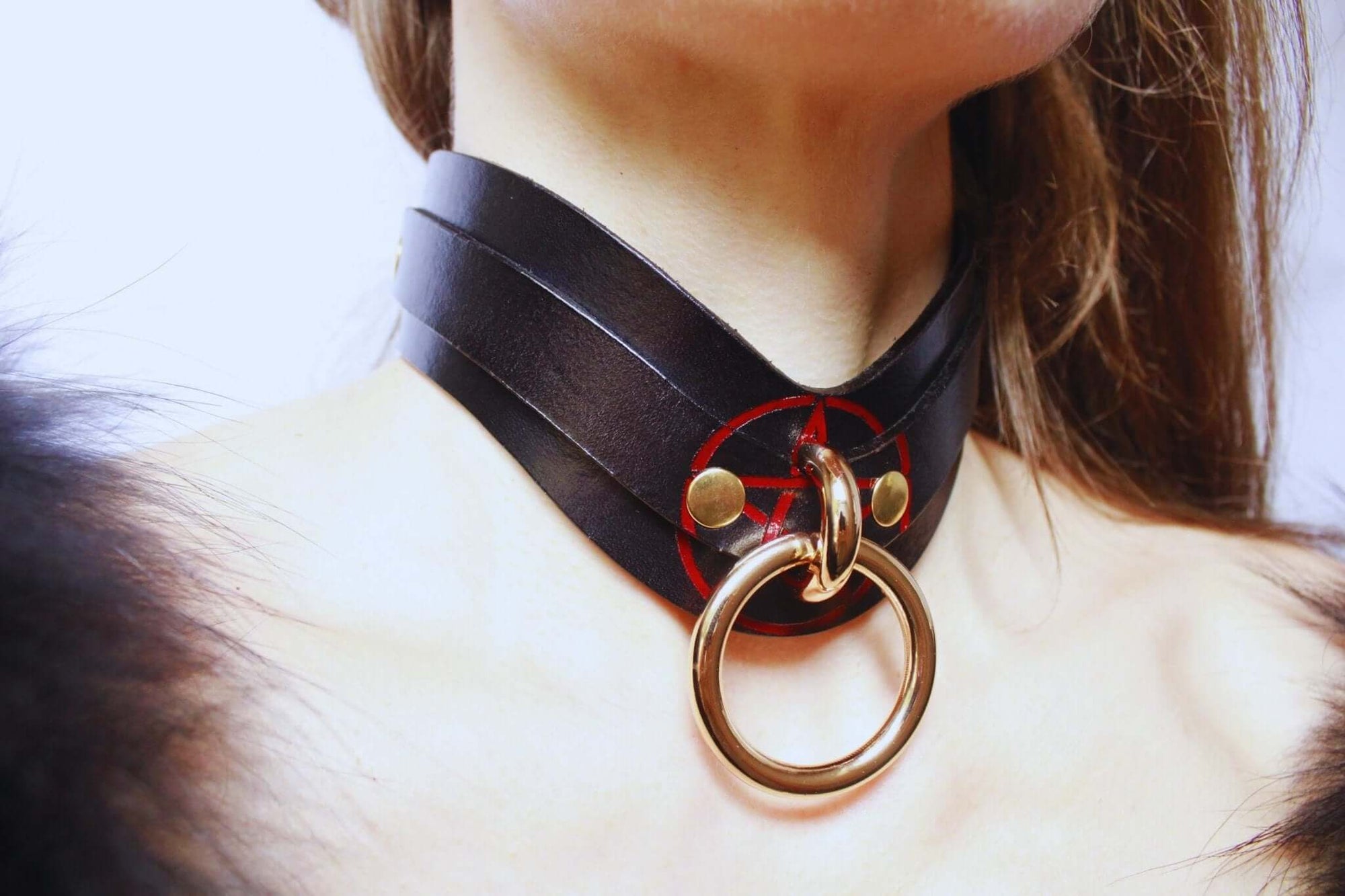 Elegant black leather pentagram collar with gold accents, perfect for BDSM and discreet day wear.