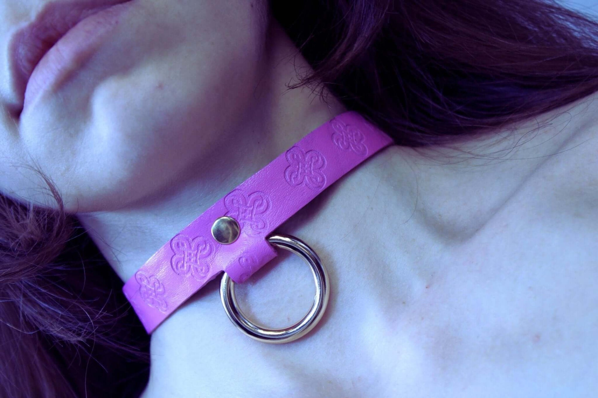 Close-up of a pink handmade leather BDSM collar with O-ring, ideal for submissive jewelry and bondage play.