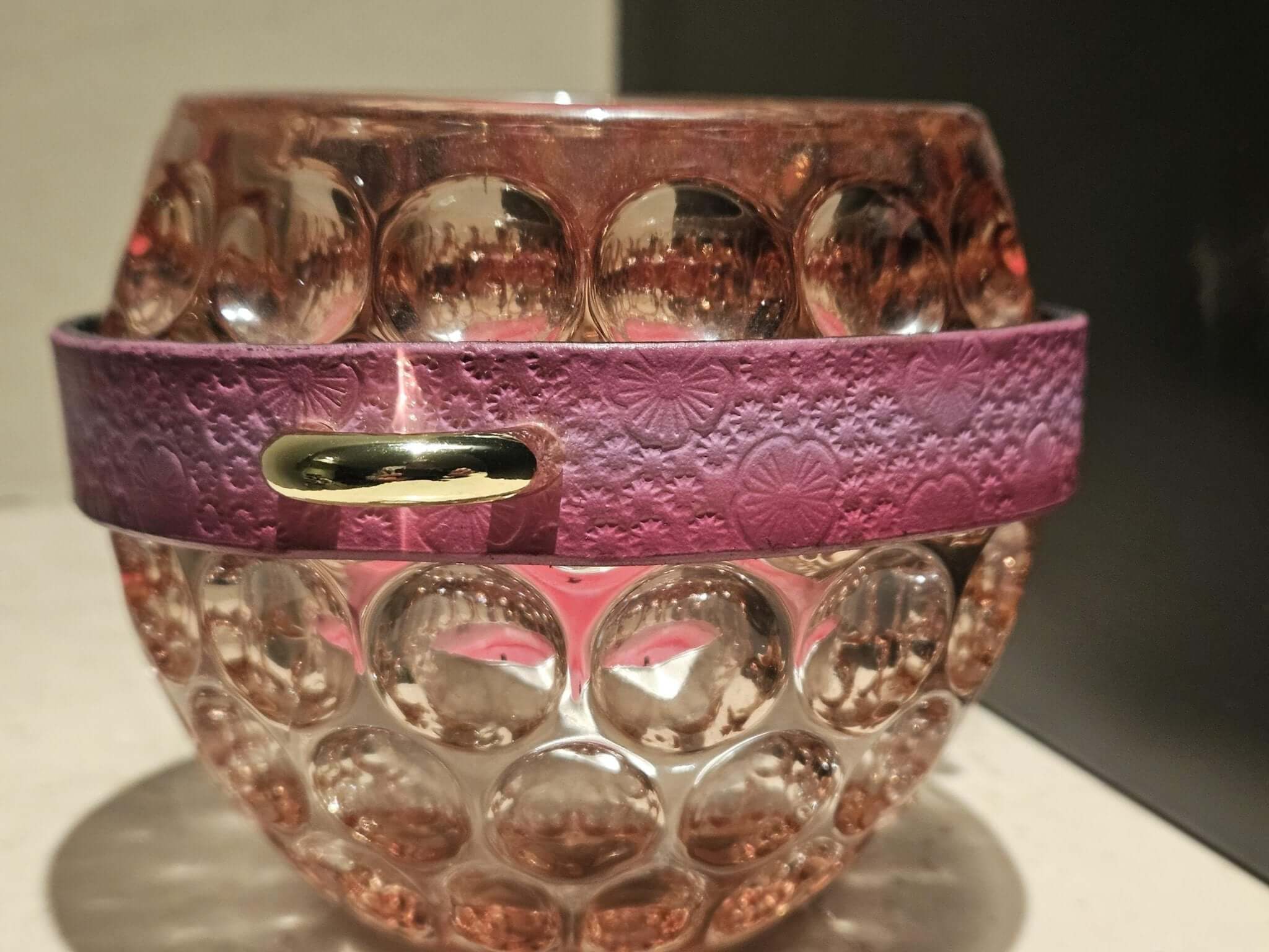 Pink floral embossed soft leather collar on a delicate glass orb, perfect for bdsm jewelry and decorative display.