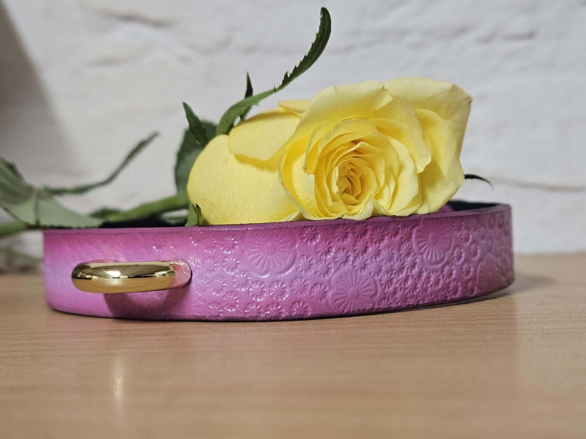 Delicate pink floral embossed leather submissive collar adorned with a gold O-ring and yellow rose, perfect for bdsm jewelry.