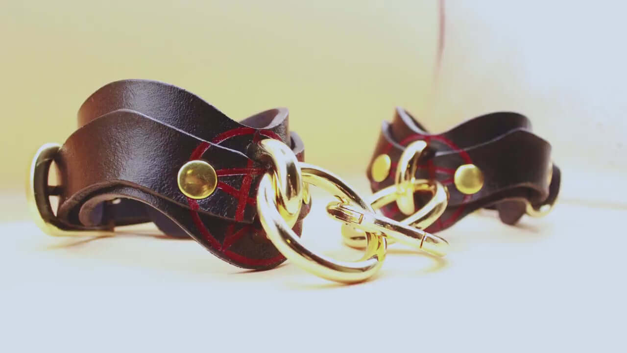 Luxurious leather BDSM cuffs with gold hardware, perfect for bondage gear and submissive jewelry, enhancing erotic experiences.