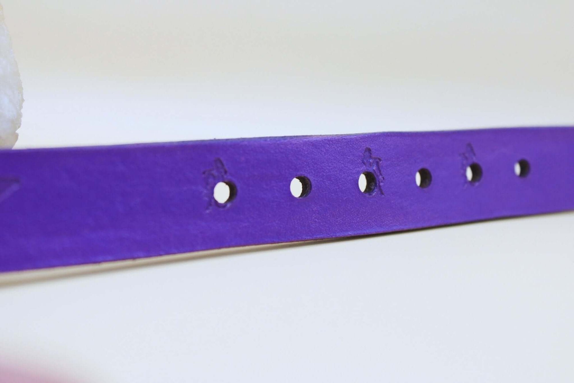 Purple BDSM collar strap showcasing holes for adjustable fit, perfect for submissive jewelry and bondage aesthetics.
