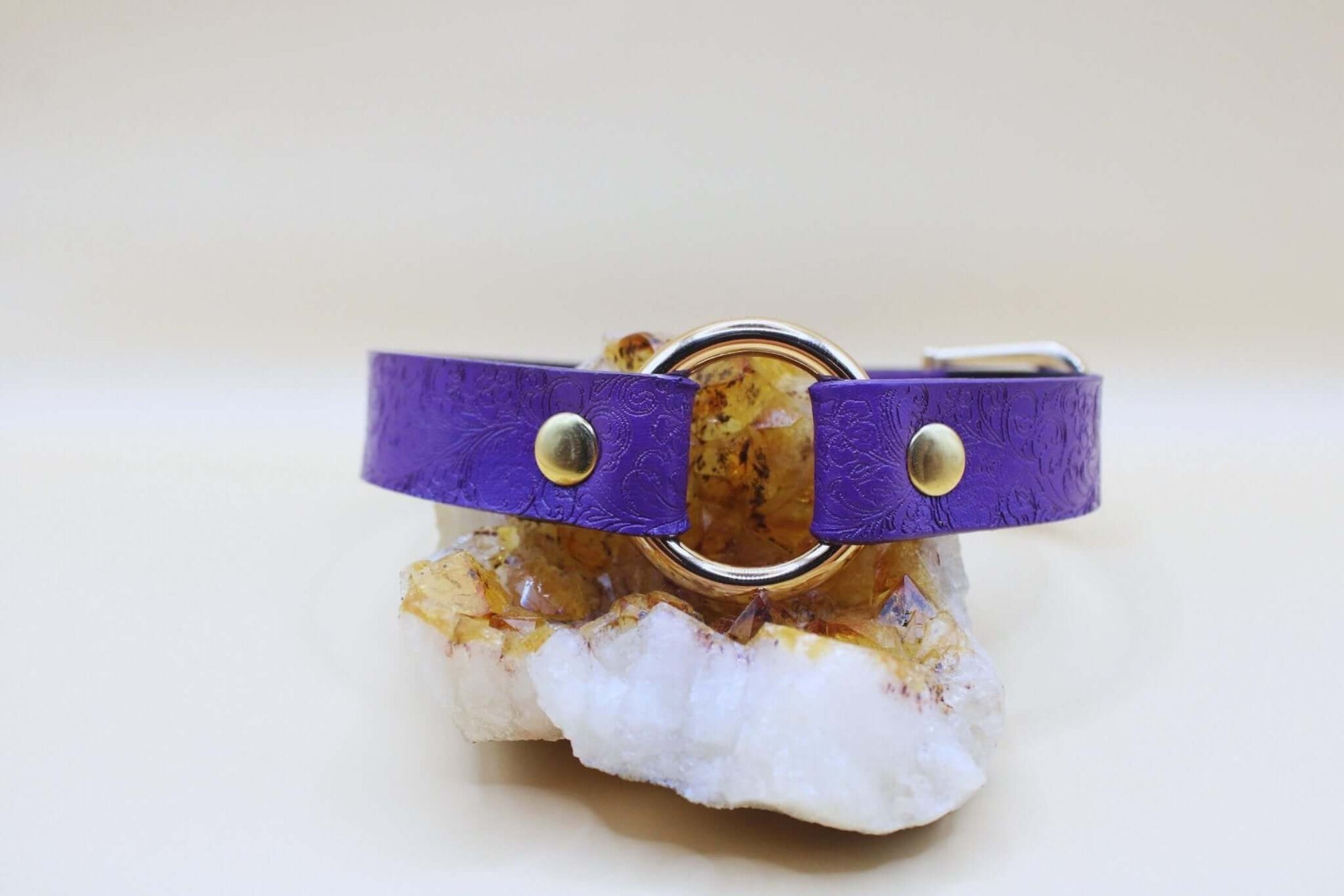 Purple leather O-ring choker collar on a crystal base, ideal for submissive jewelry and BDSM accessories.