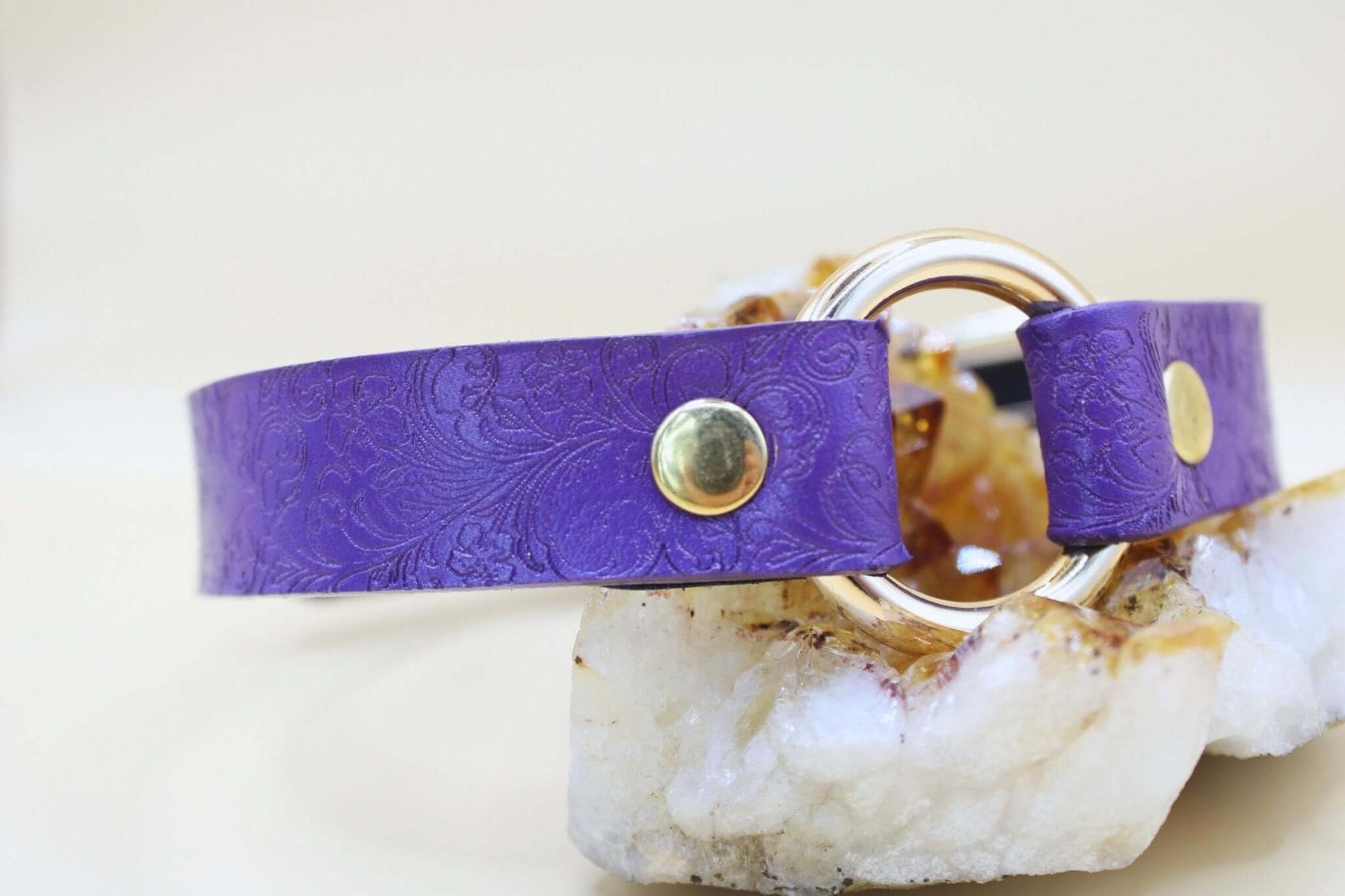 Purple leather O-ring choker collar with embossed floral design, perfect for BDSM and submissive jewelry.