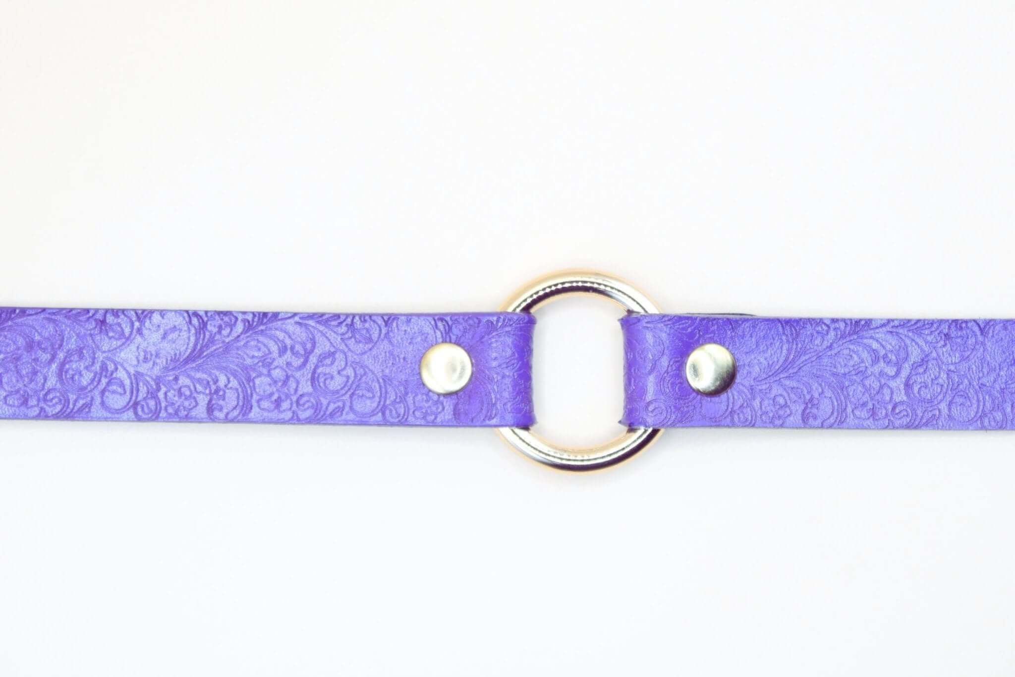 Purple leather O-ring choker collar, BDSM submissive jewelry with embossed floral design.