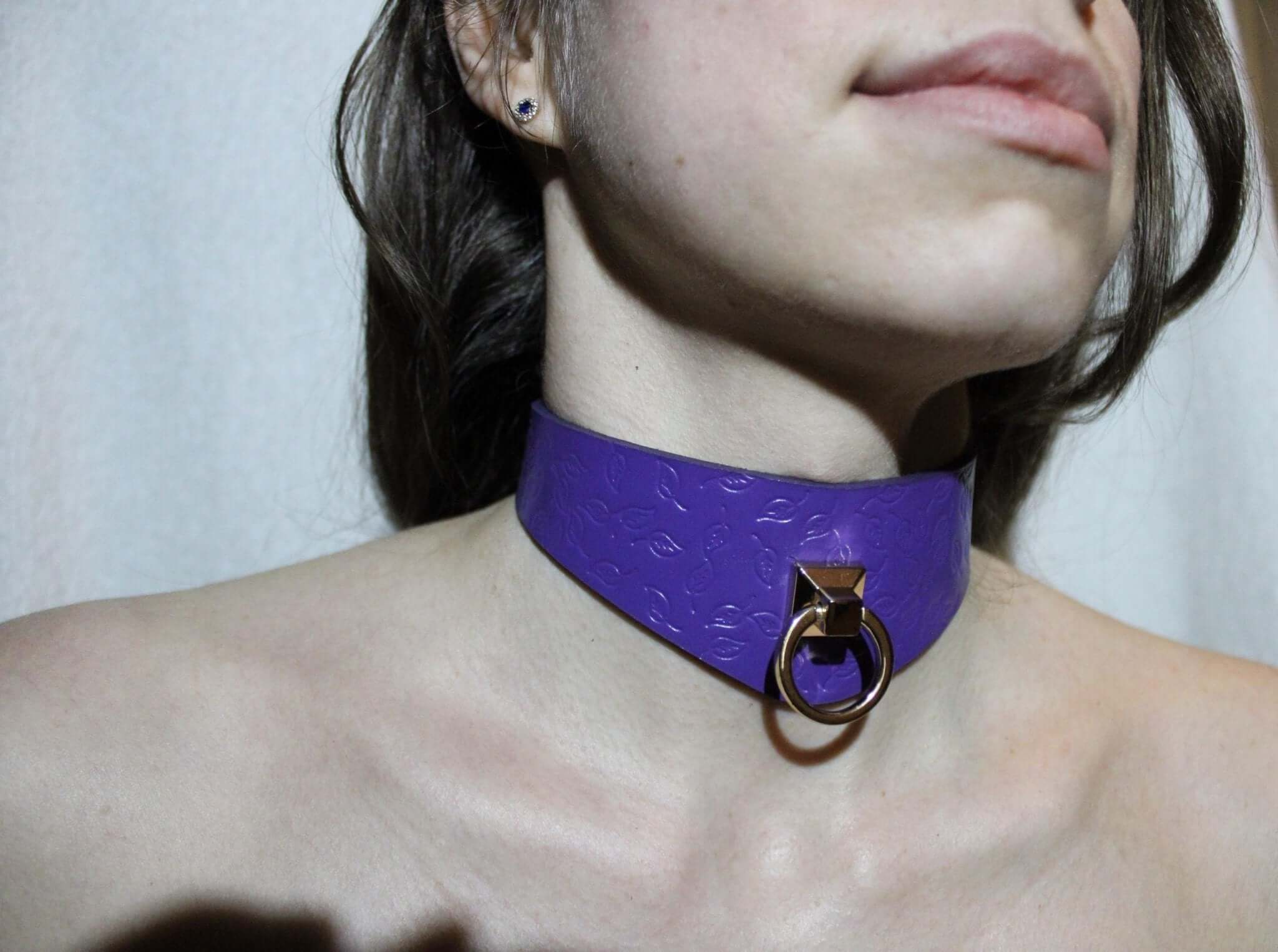 Purple leather BDSM collar with D-ring, symbolizing submission and style in bondage and submissive jewelry.
