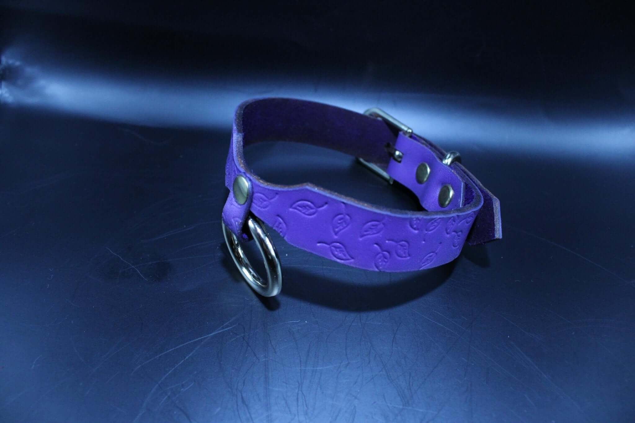 Elegant purple leather BDSM collar with embossed leaf design and O-ring, perfect for submissive jewelry and bondage attire.