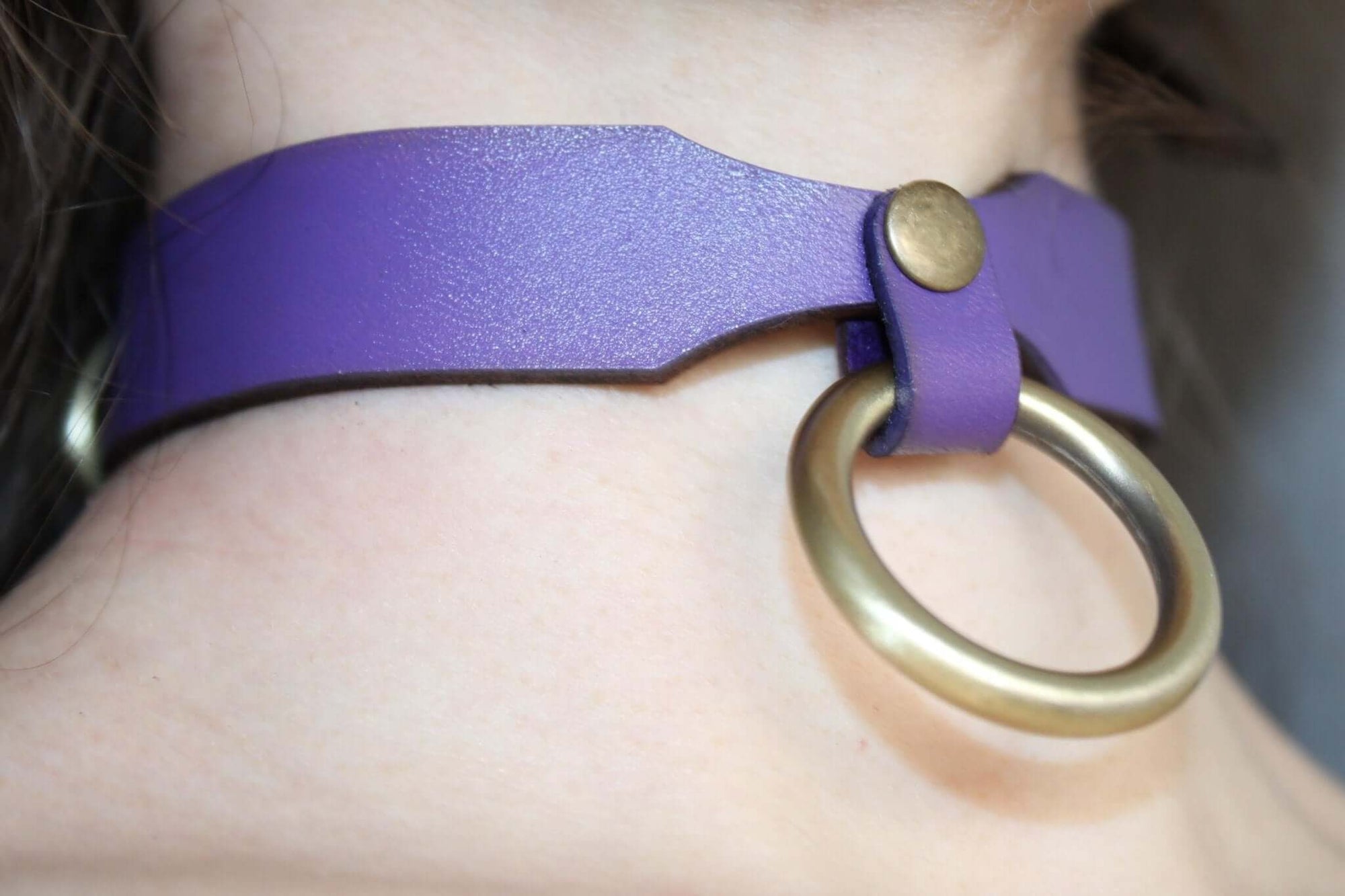 Purple leather submissive collar with a gold ring, perfect for bondage and BDSM aesthetics.