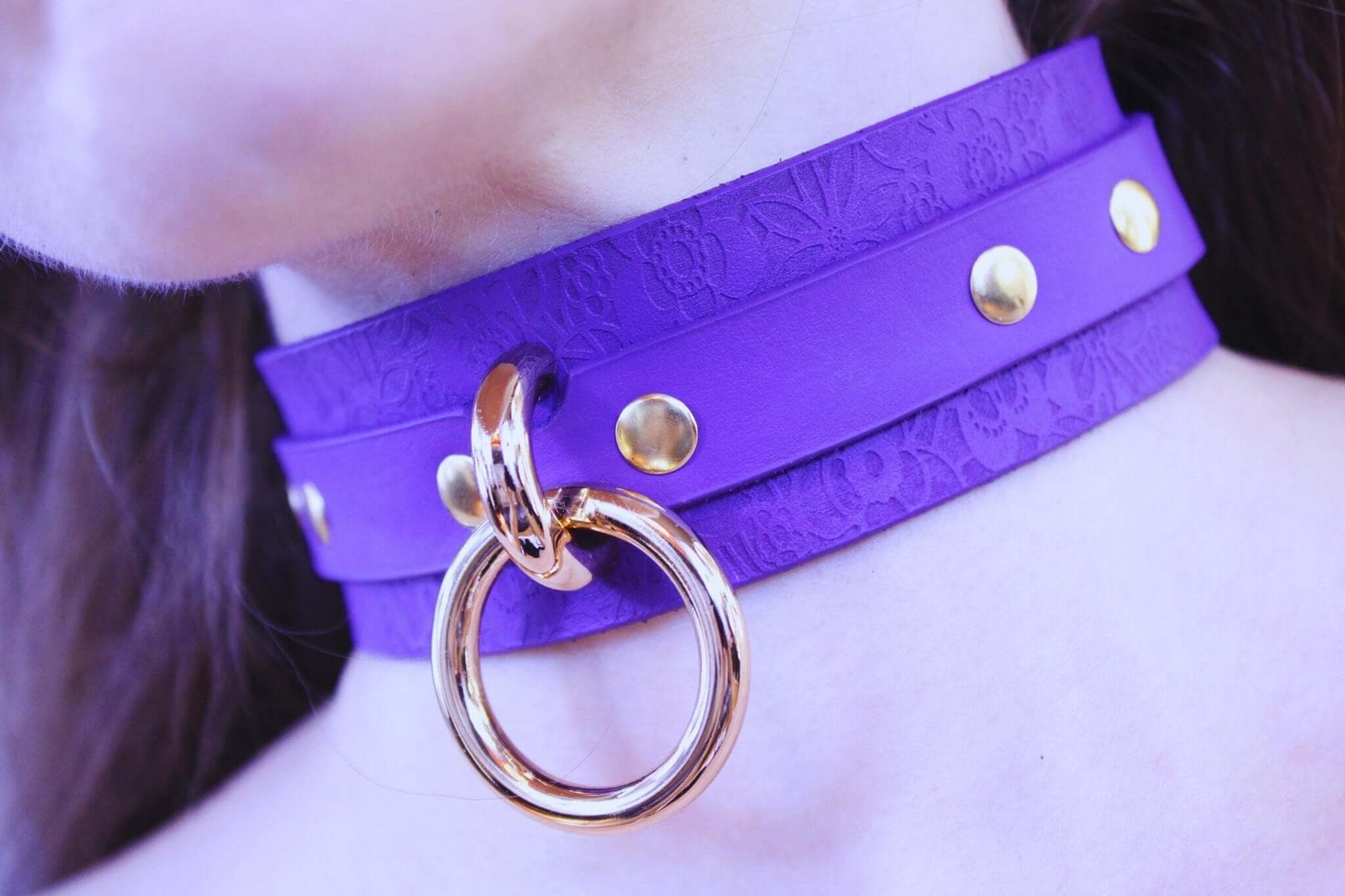 Elegant purple leather choker with gold studs and ring, perfect for BDSM and discreet day wear.