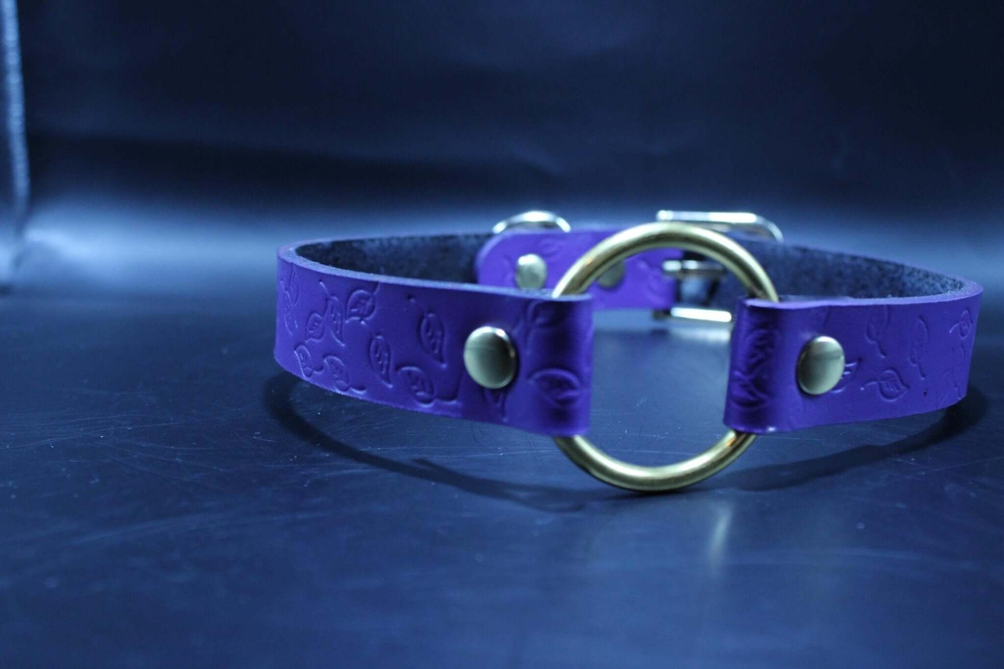 Purple leather submissive collar with brass ring, embossed design, perfect for BDSM and petplay. Quality bondage accessory.