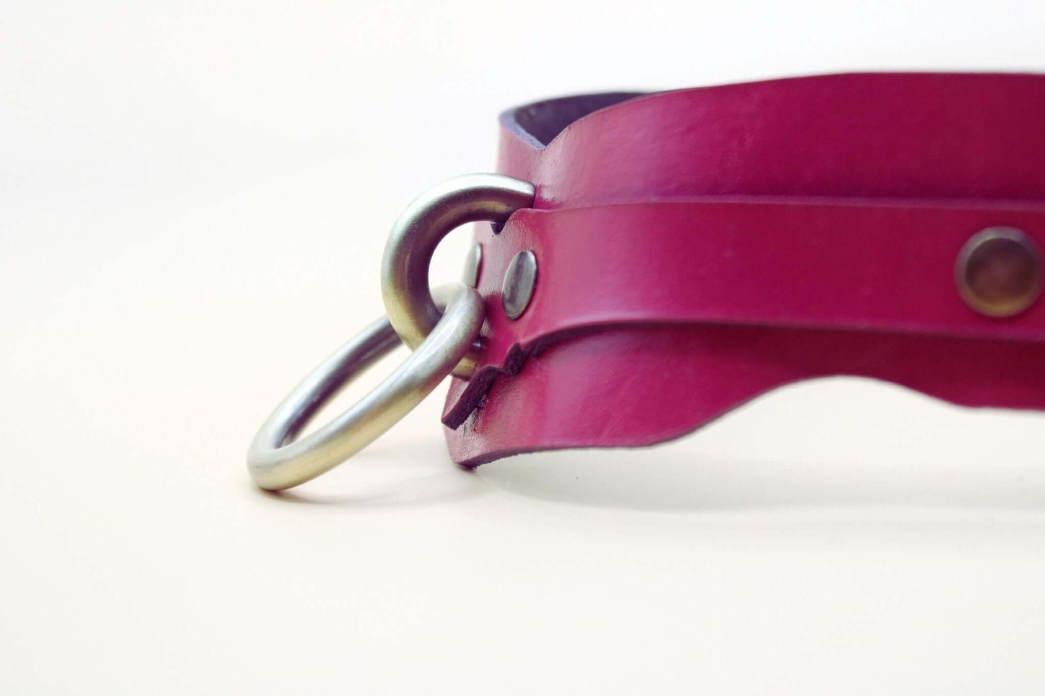 Raspberry leather BDSM collar featuring a brass O-ring, perfect for submissive jewelry and discreet day collar wear.