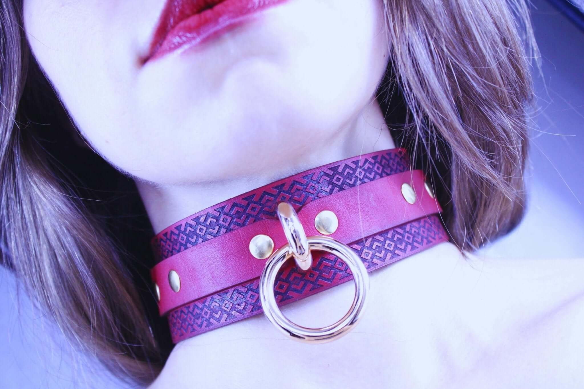 Handcrafted red BDSM collar with tribal patterns and golden studs, perfect for submissive jewelry and bondage play.