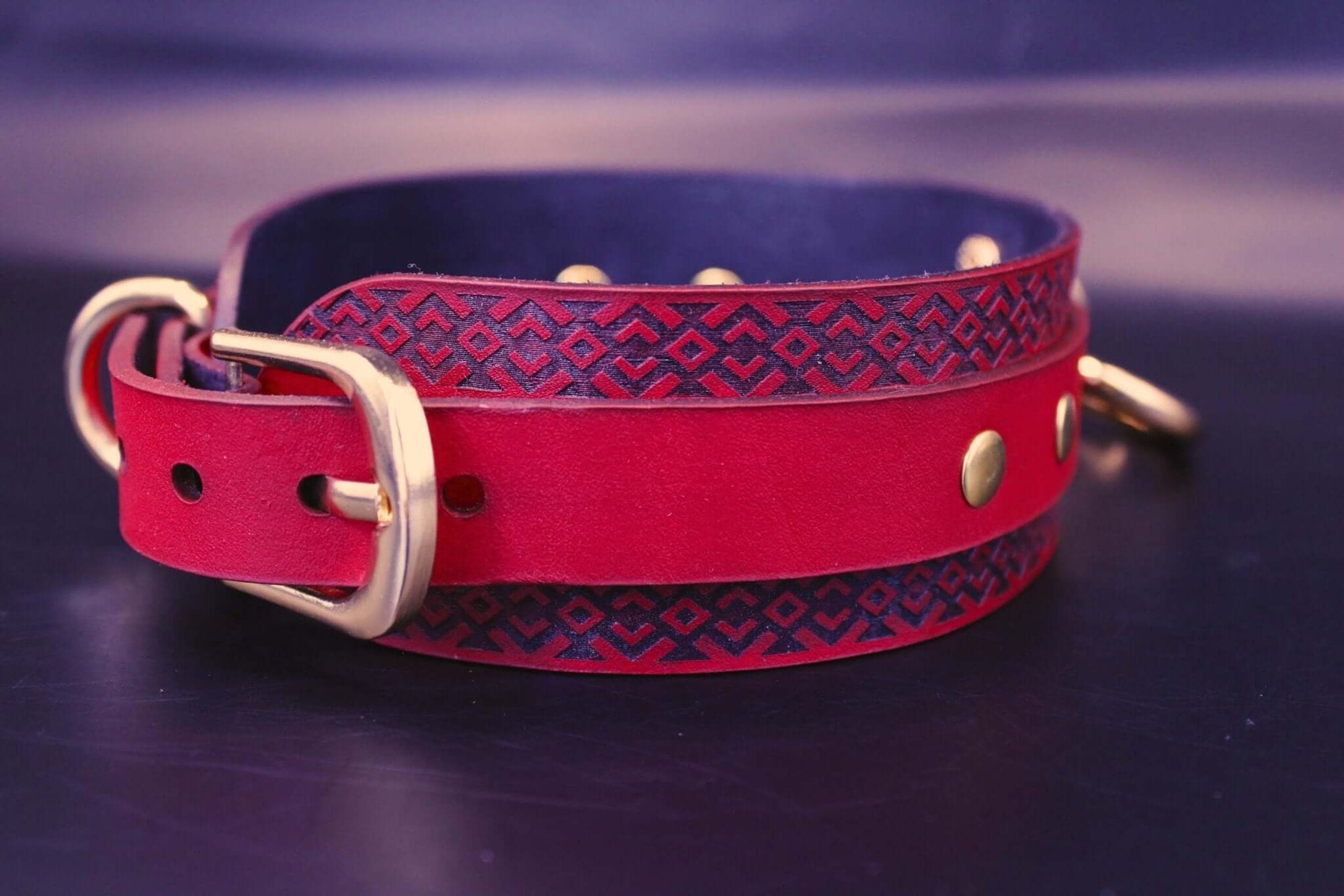 Handcrafted red BDSM collar with blue tribal patterns and gold studs, ideal for submissive jewelry and bondage gear.