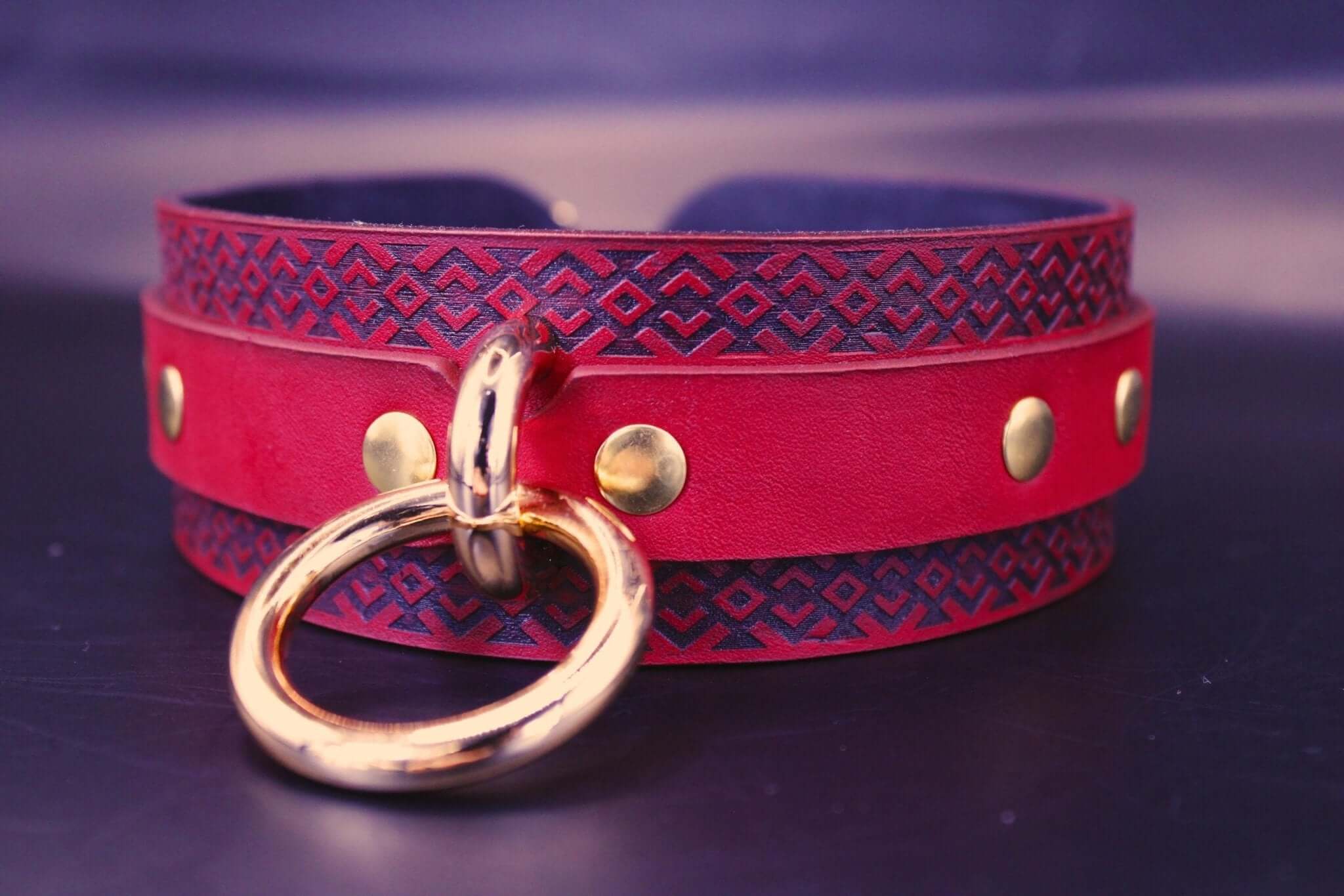 Red BDSM collar with tribal pattern, golden studs, perfect for submissive jewelry and dominance play.