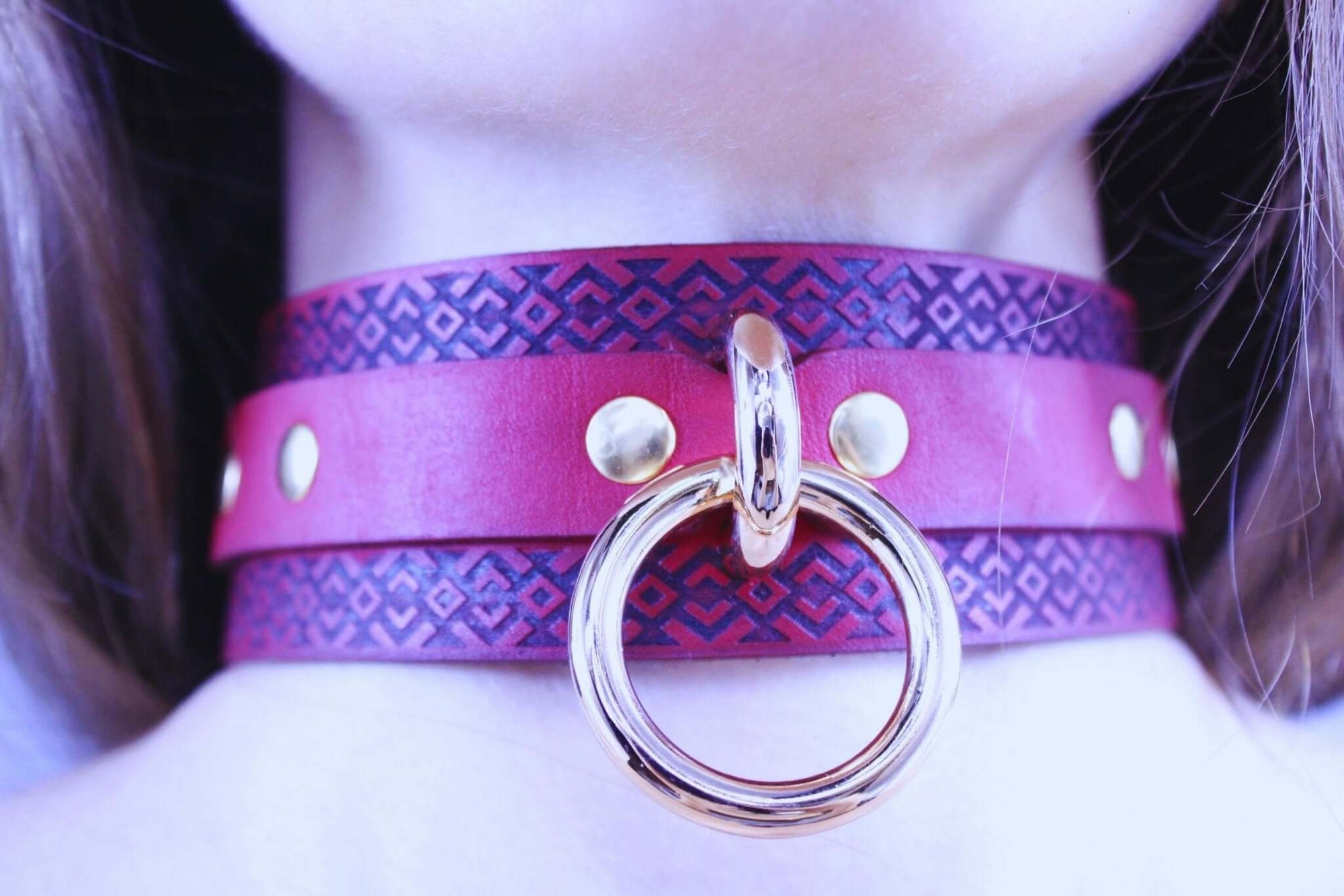 Red leather BDSM collar with tribal pattern and gold ring, ideal for submissive jewelry and bondage play.
