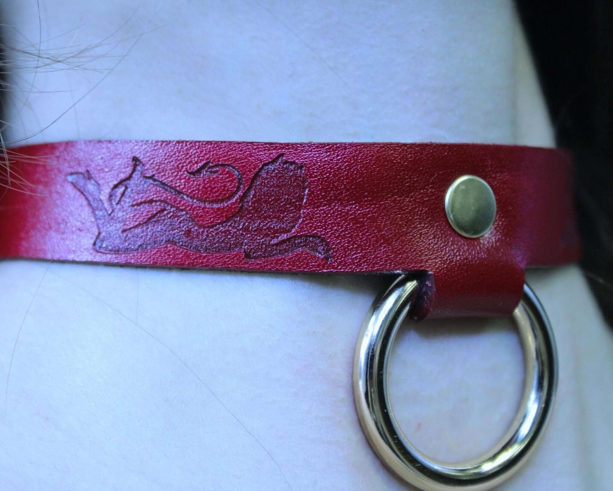 Red leather submissive collar with devil tail design and O-ring, perfect for BDSM and bondage ensembles.
