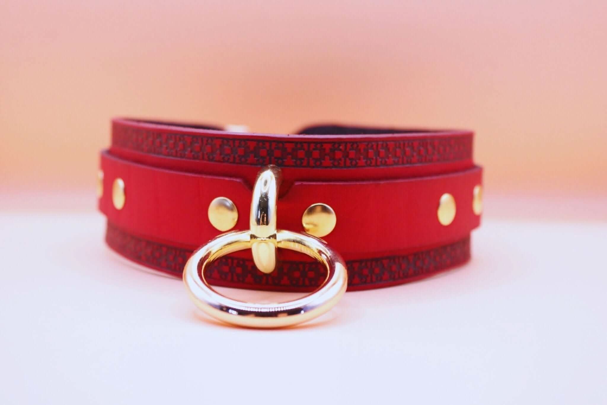 Red posture collar with golden ring, perfect for BDSM play, combining elegance and seduction in leather lingerie fashion.