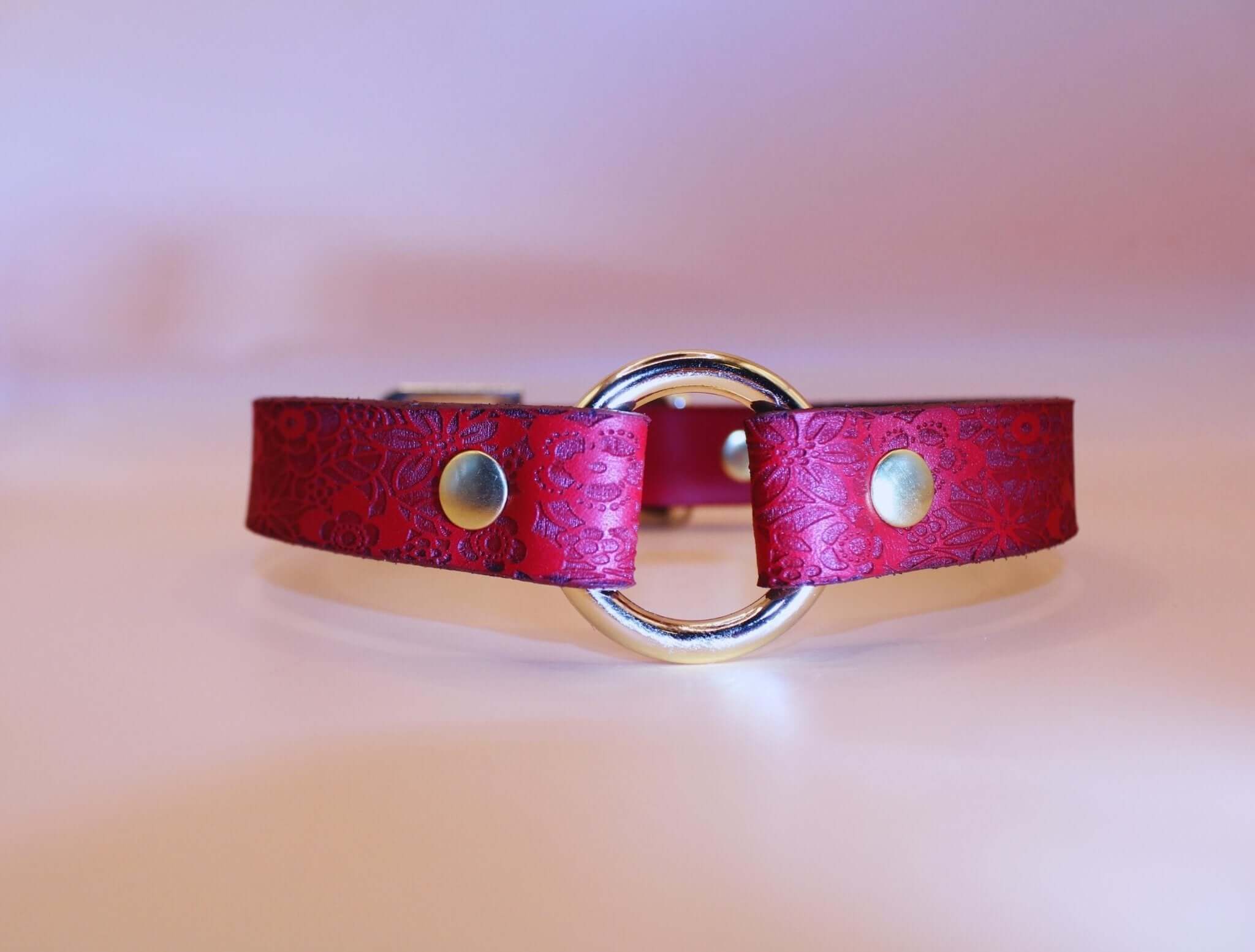 Elegant red floral leather submissive collar with gold O-ring, perfect for BDSM, self-bondage, and stylish submissive jewelry.
