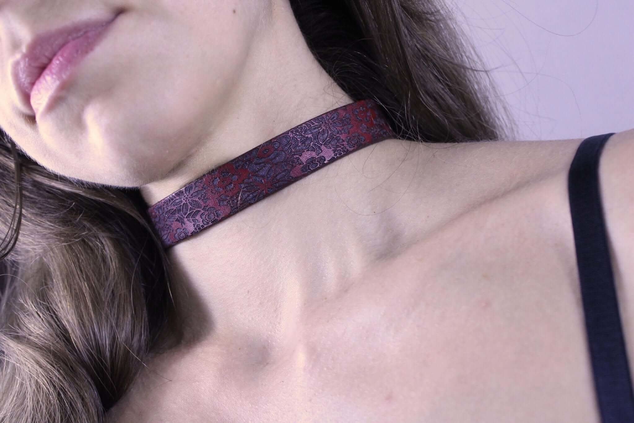 Dark red floral submissive collar worn as discreet BDSM jewelry for elegant bondage fashion.