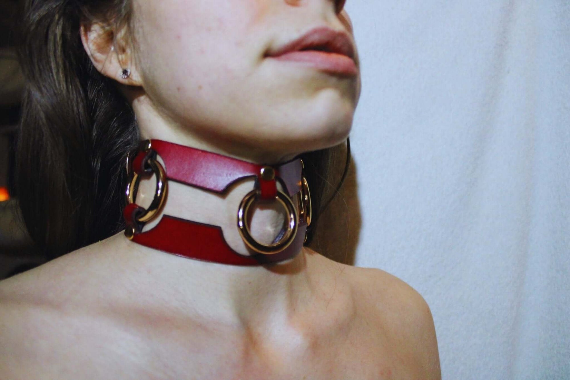 Red leather submissive collar with bold rings, perfect for BDSM and bondage aesthetics. Ideal statement jewelry for power dynamics.