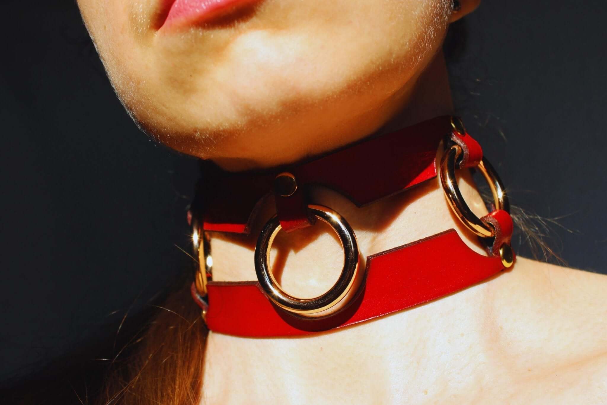 Bold red leather BDSM collar with metal rings, perfect for submissive jewelry and bondage aesthetics.