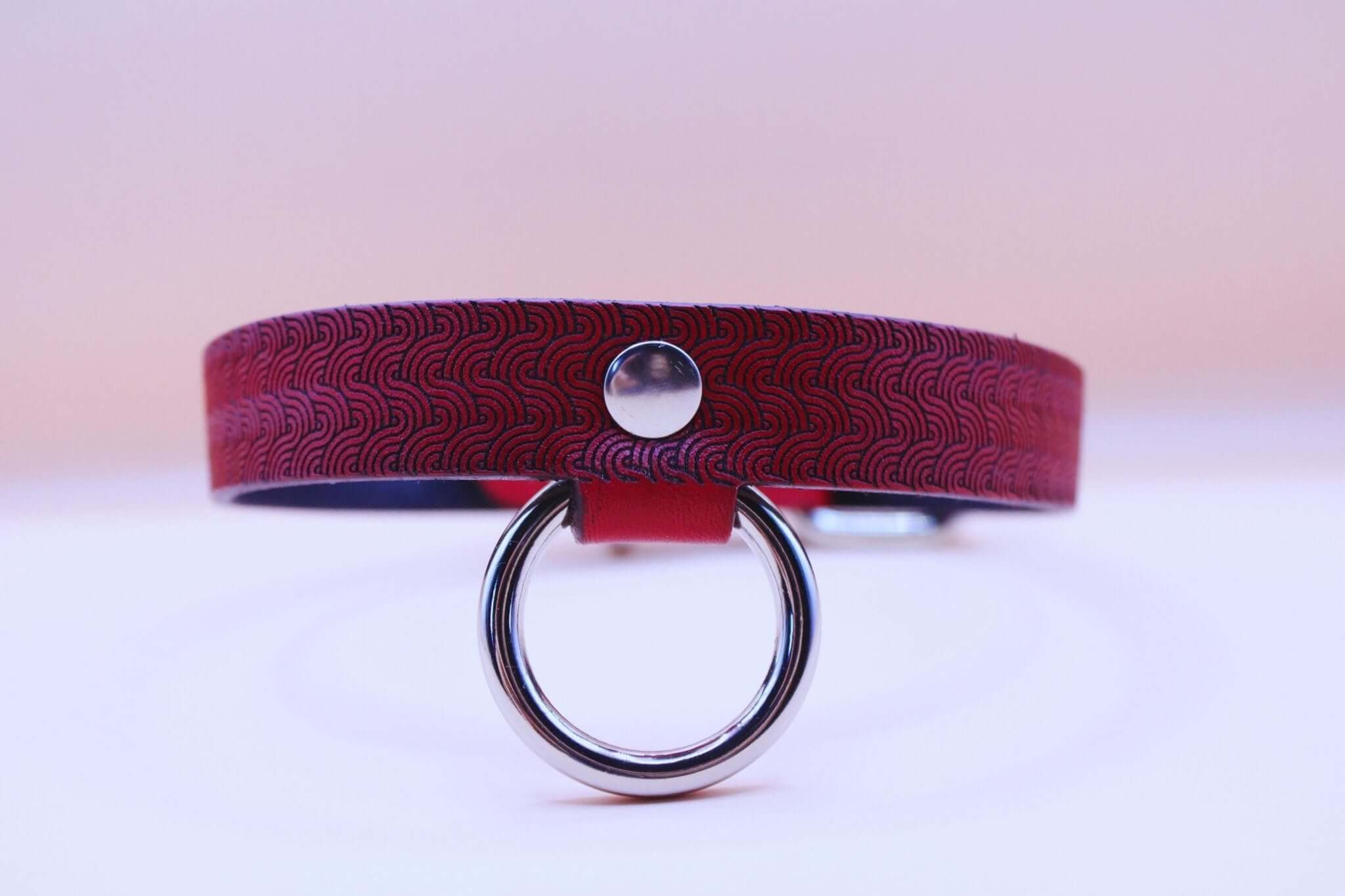 Red patterned leather submissive collar with O-ring, perfect for BDSM, bondage, and discreet day wear.