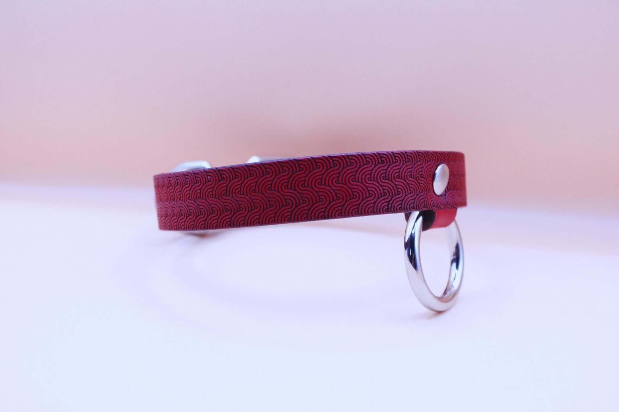 Red patterned leather submissive collar with O-ring, ideal for BDSM and bondage enthusiasts.