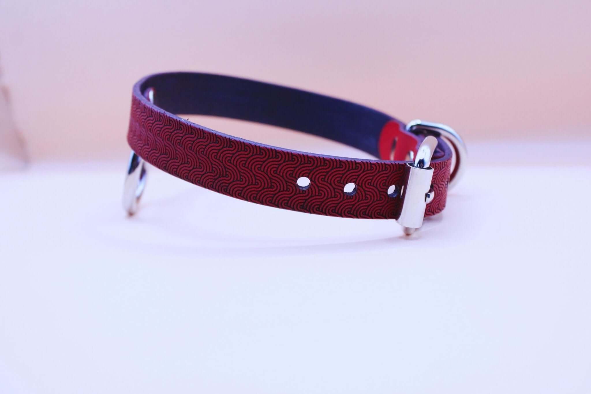 Red patterned leather submissive collar with O-ring, ideal for BDSM and bondage gear, combining style and power.