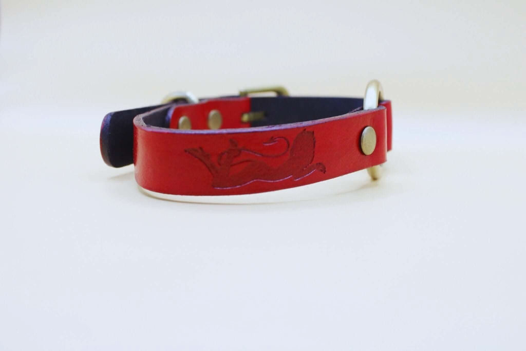 Handcrafted red leather submissive collar with embossed feline design, ideal for bdsm and everyday elegant wear.