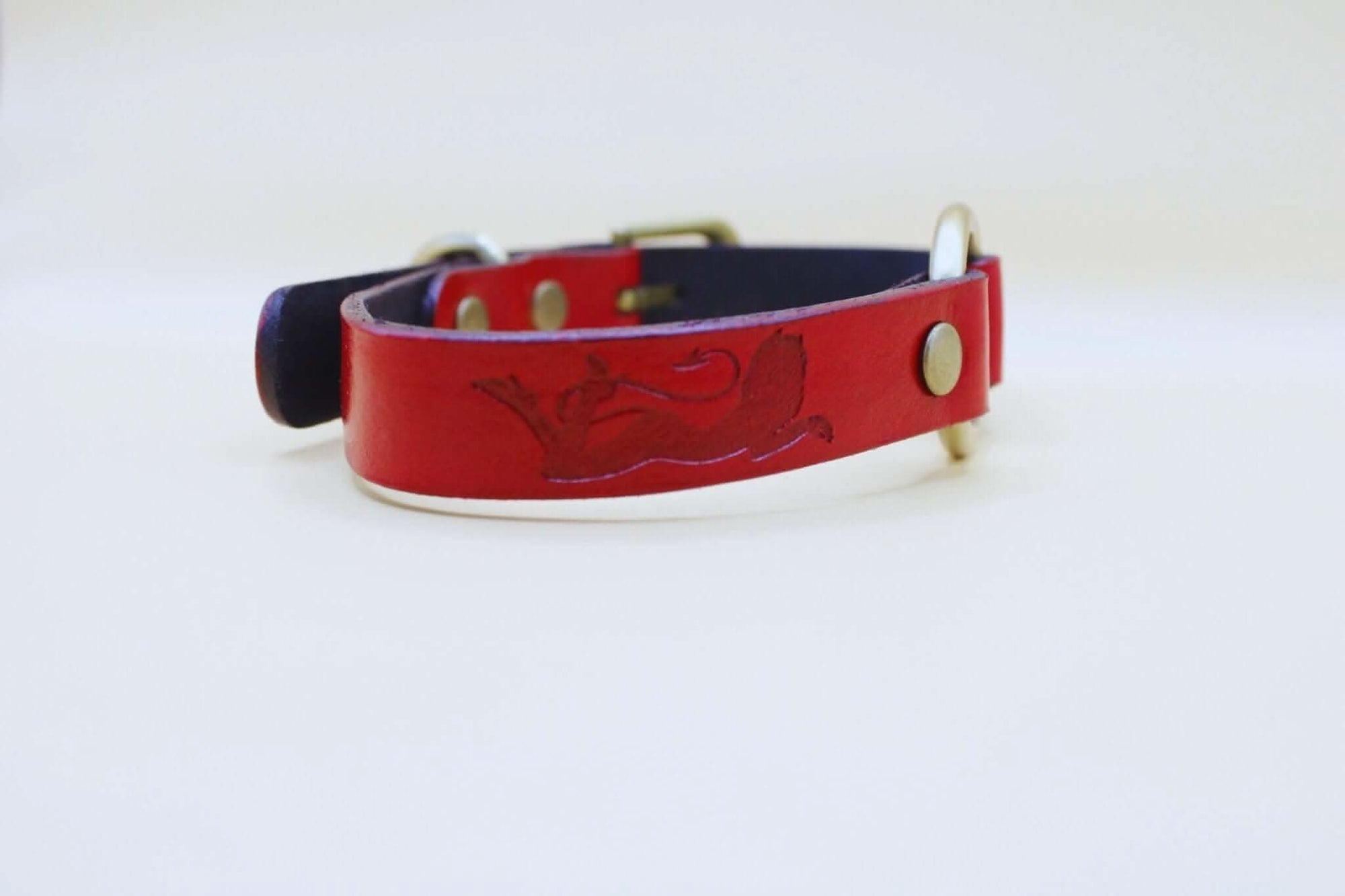 Handcrafted red leather submissive collar with embossed feline design, ideal for bdsm and everyday elegant wear.