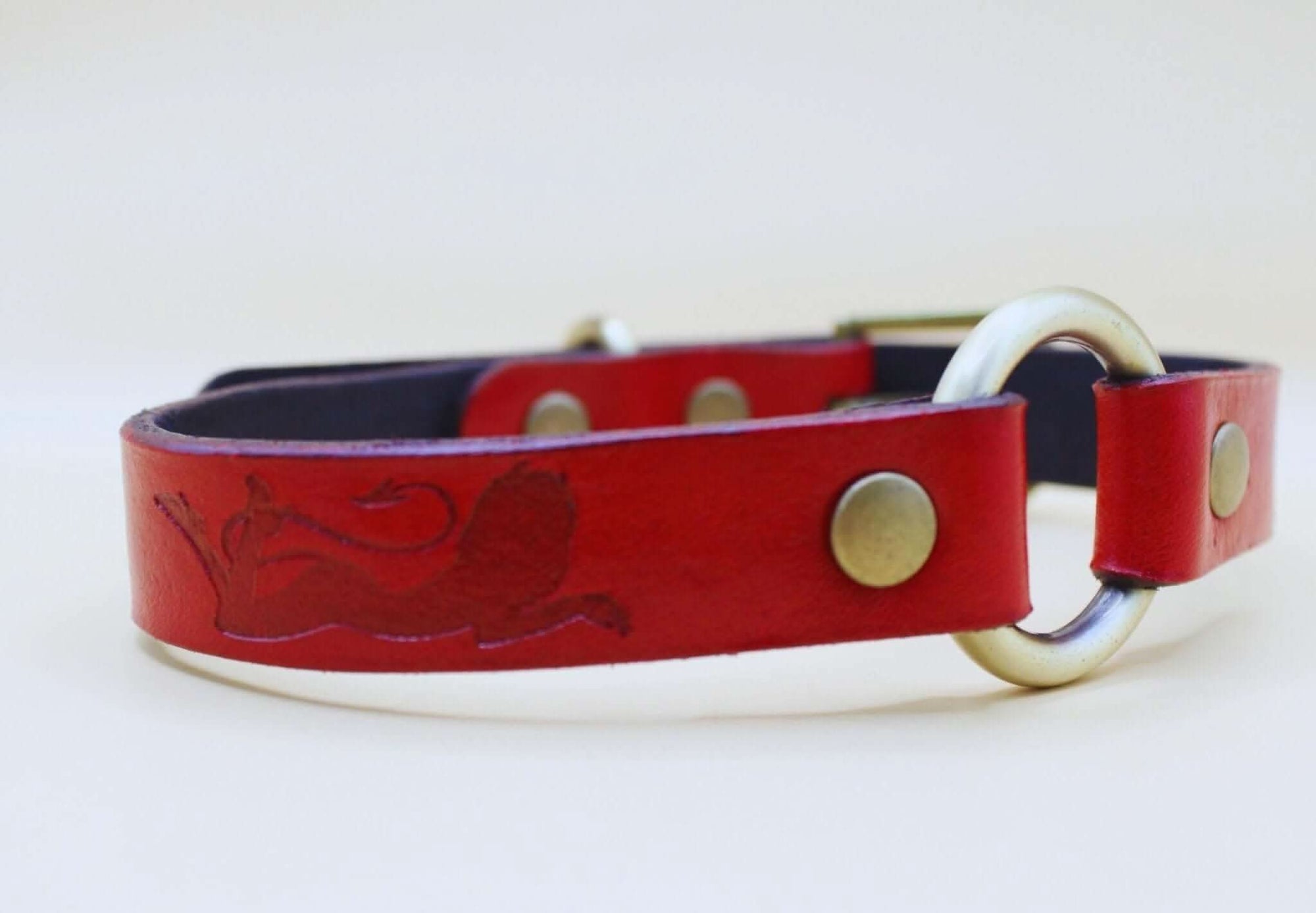 Red leather submissive collar with embossed feline silhouette, ideal for BDSM, everyday wear, and intimate moments.