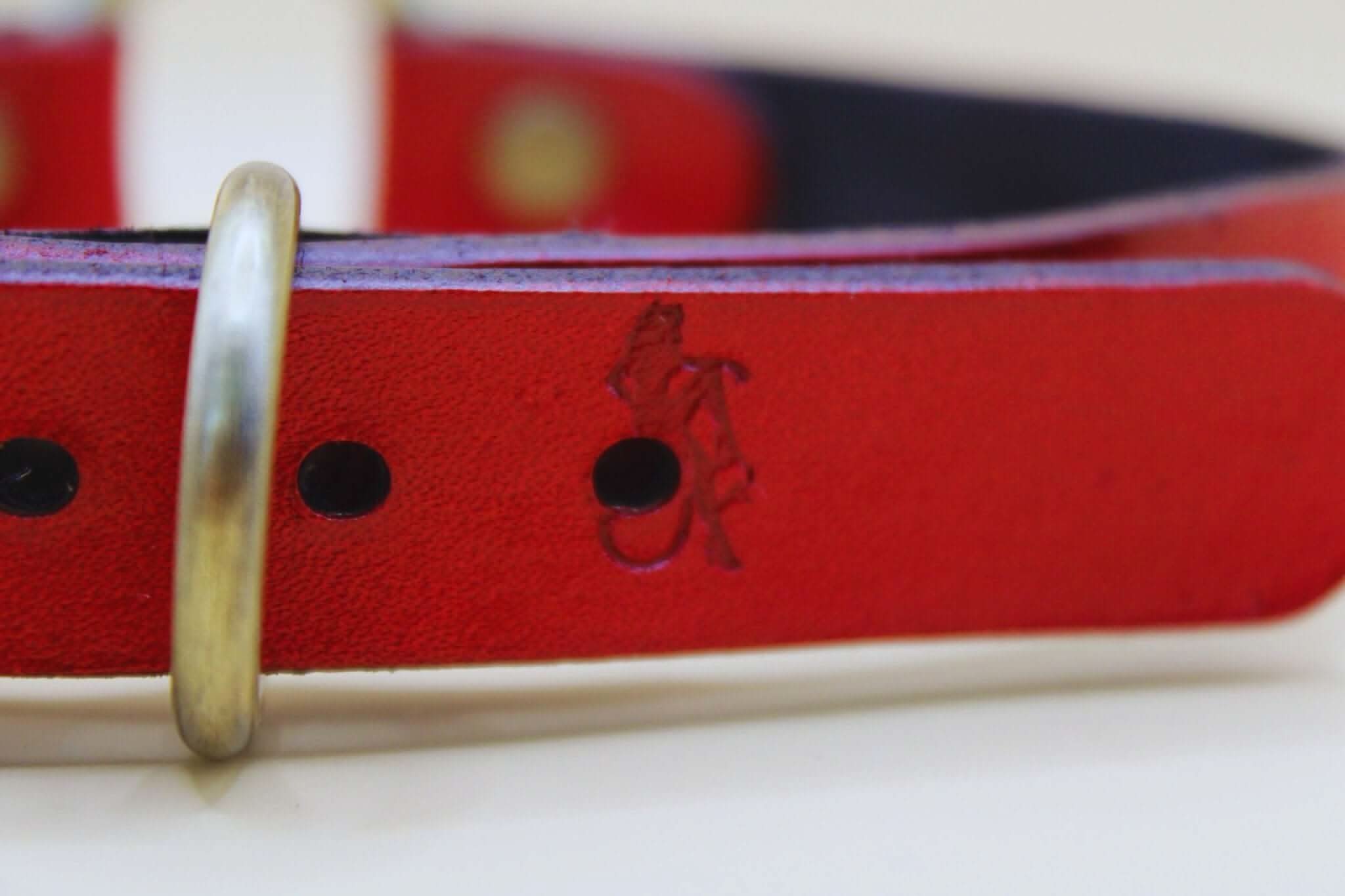 Close-up of a red leather submissive collar featuring embossed design and metal ring, ideal for BDSM and bondage play.
