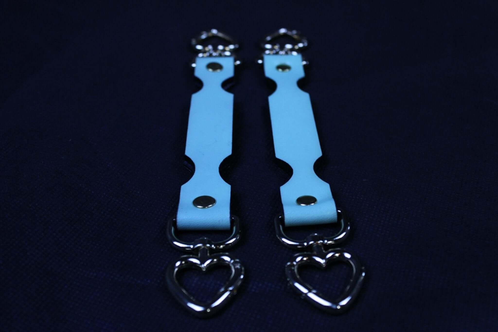 Short BDSM connector in blue leather with heart-shaped clips for secure restraint in bondage play.
