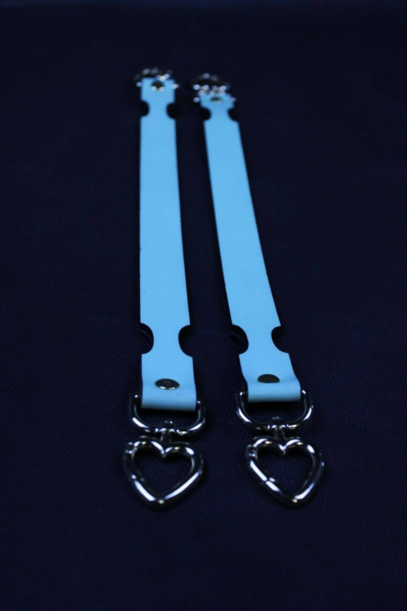 Short blue BDSM connector straps with heart-shaped metal clips, ideal for bondage gear and restraint play.