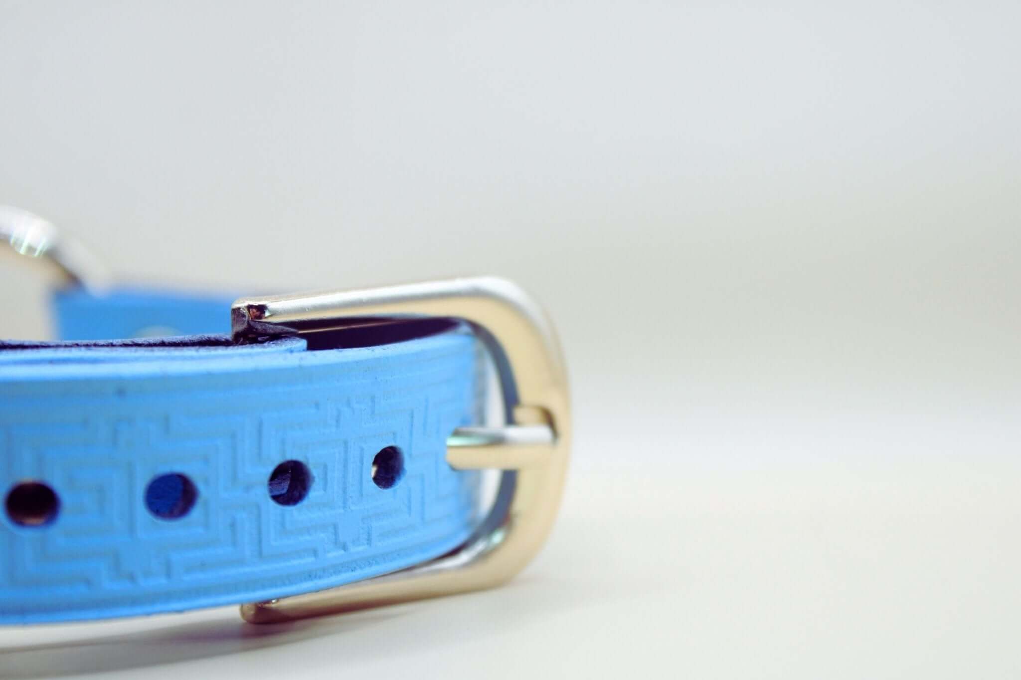 Close-up of sky blue leather sub collar with embossed geometric pattern and silver buckle, perfect for BDSM jewelry and discreet wear.