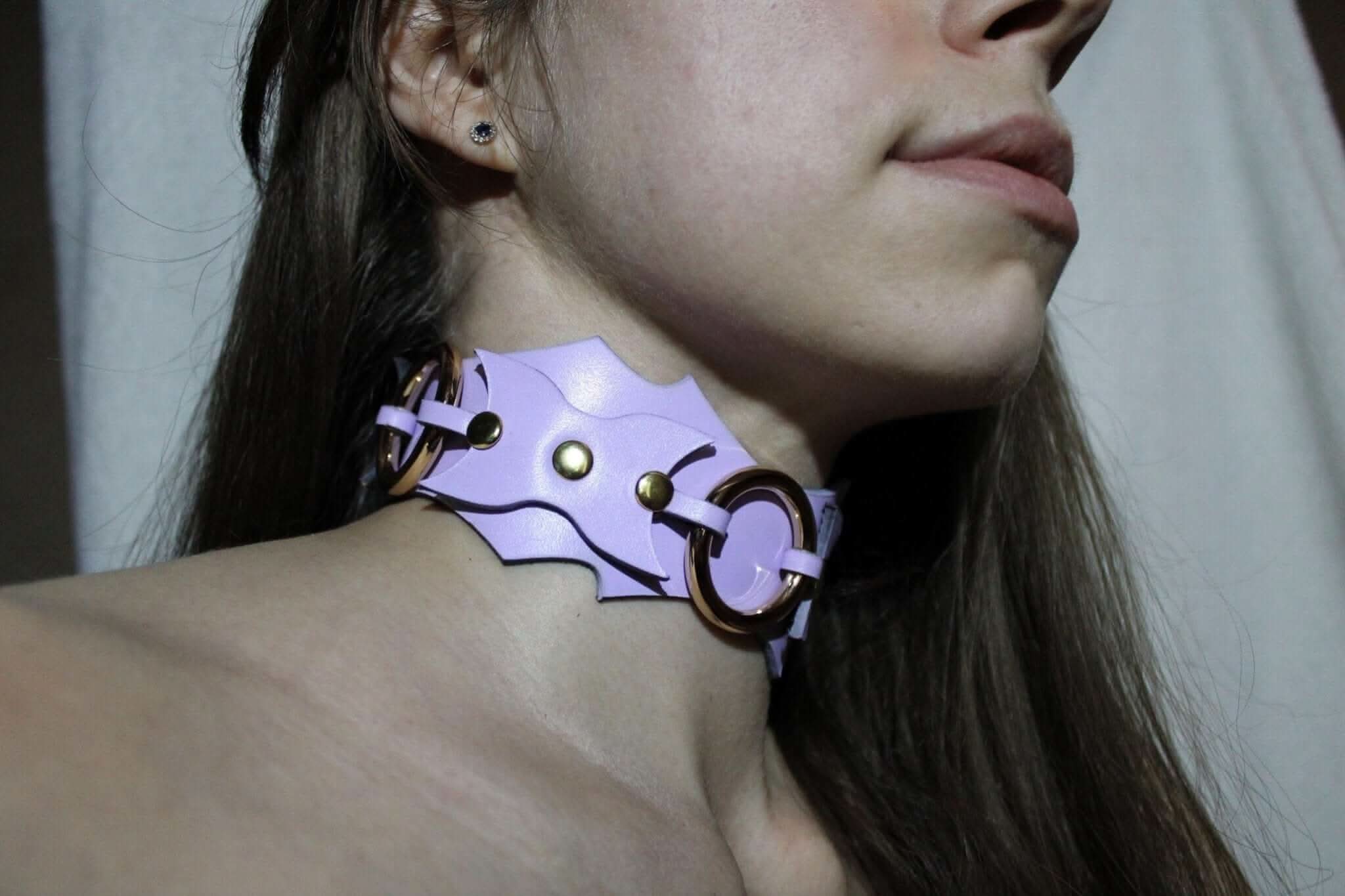 Leather submissive collar with unique batwing design and central O-ring for BDSM fashion and self-expression.