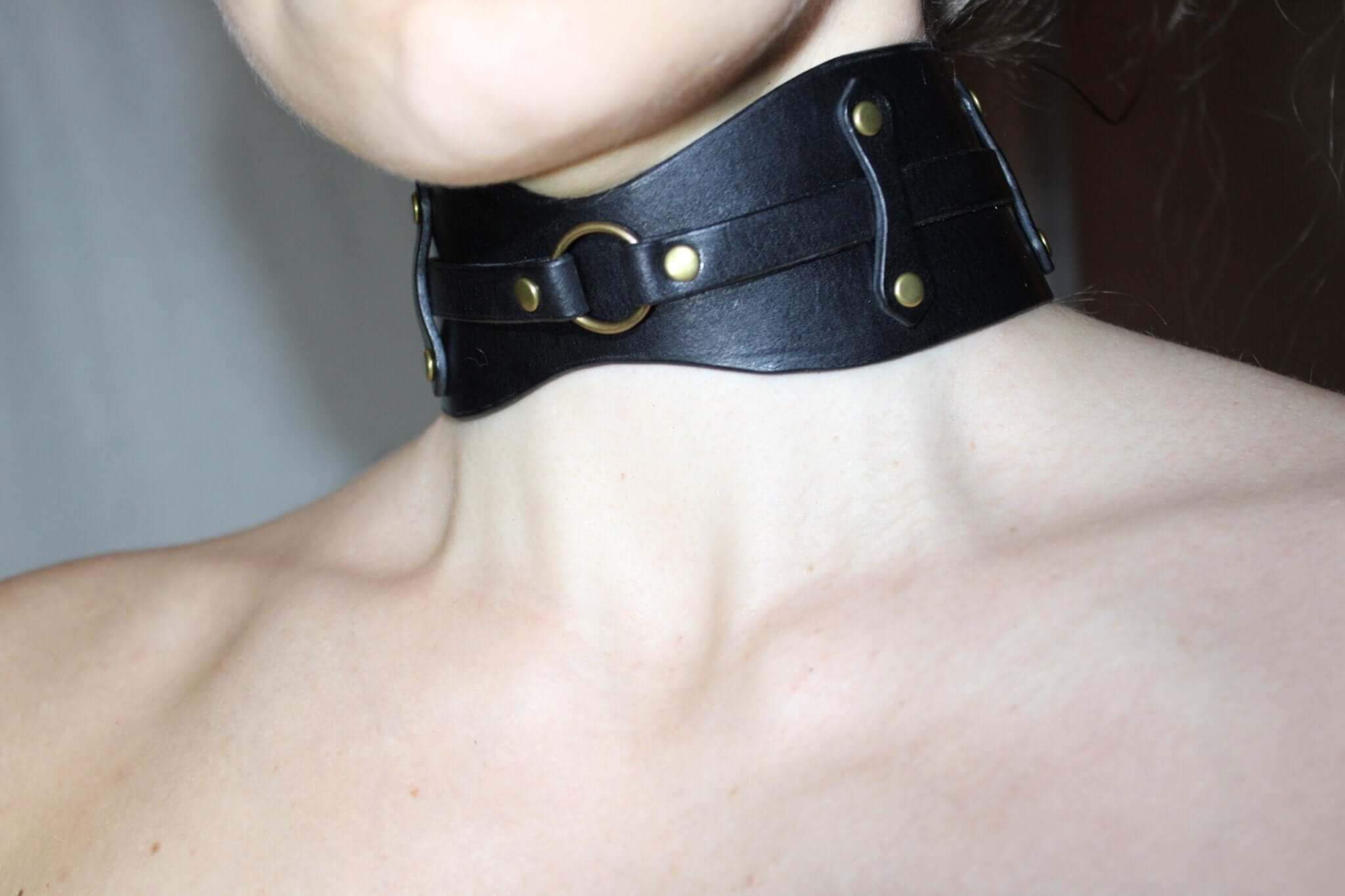 Bold black leather choker with O-ring, perfect submissive collar for BDSM and edgy fashion statements.
