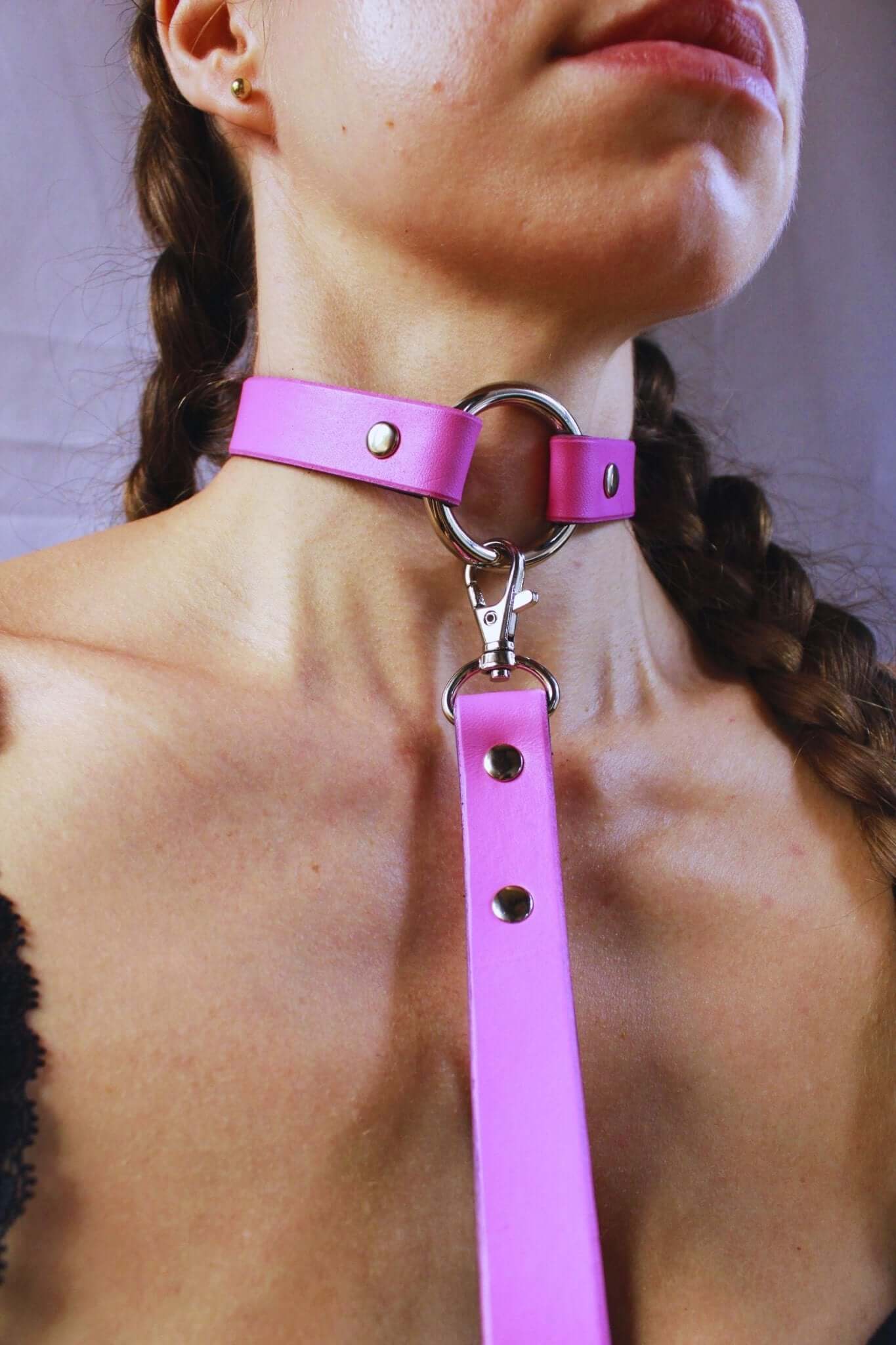 Elegant pink leather submissive collar with silver hardware, ideal for discreet daywear and BDSM fashion.