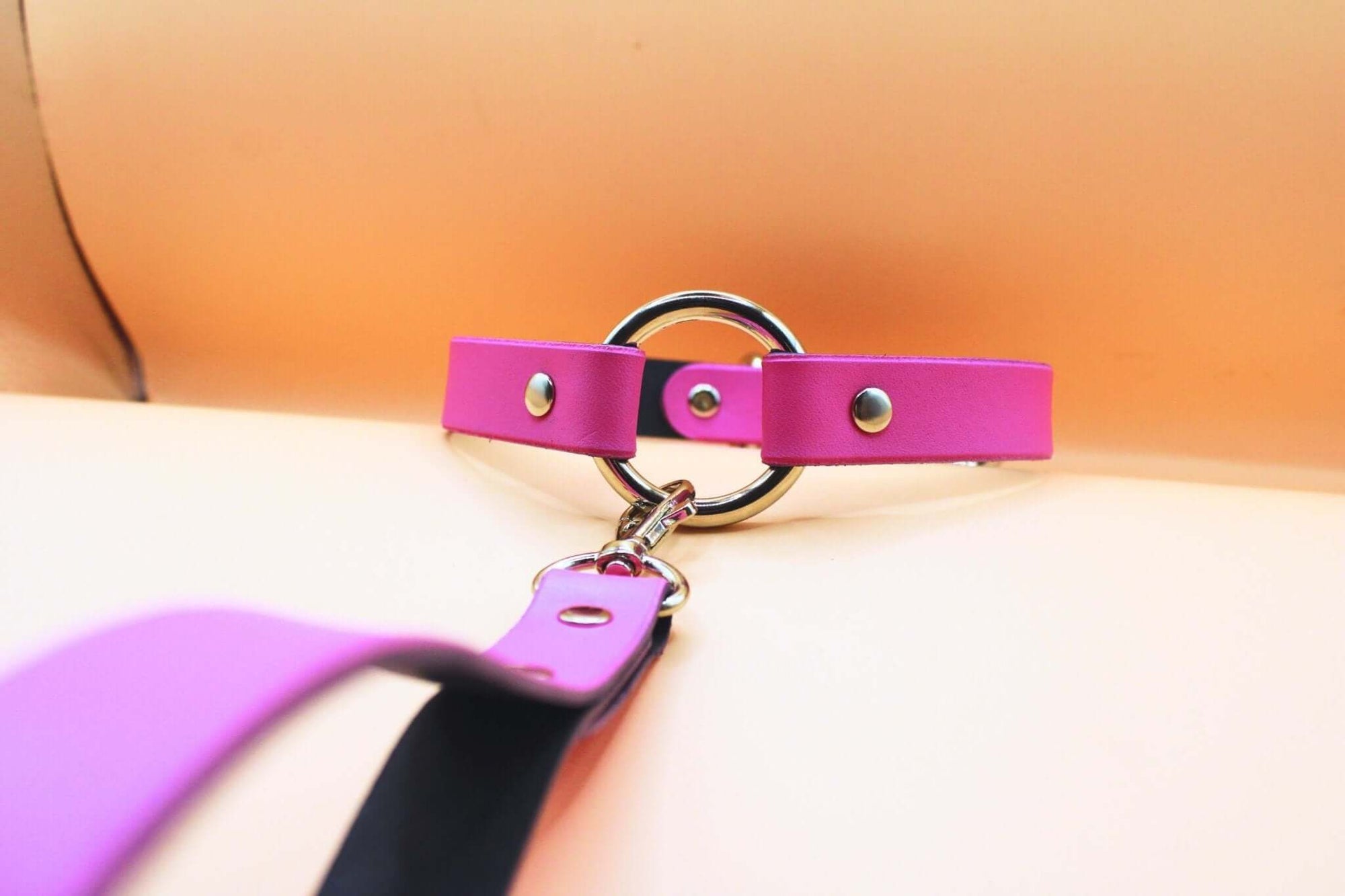 Elegant pink leather submissive collar with metal ring, perfect for discreet daywear and BDSM fashion.