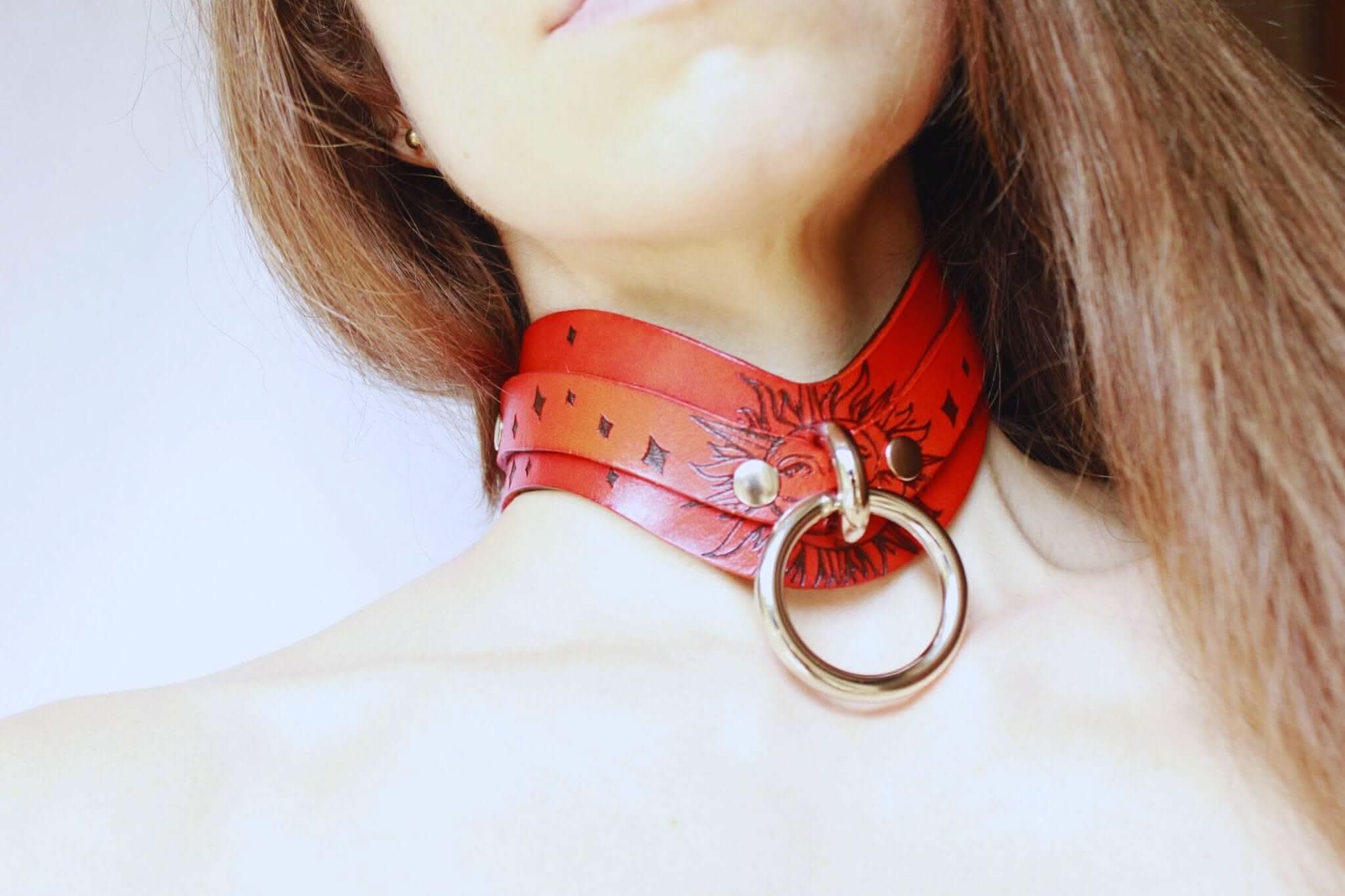 Discreet red leather BDSM collar, a stylish submissive jewelry piece for confident expression, ideal for day wear.
