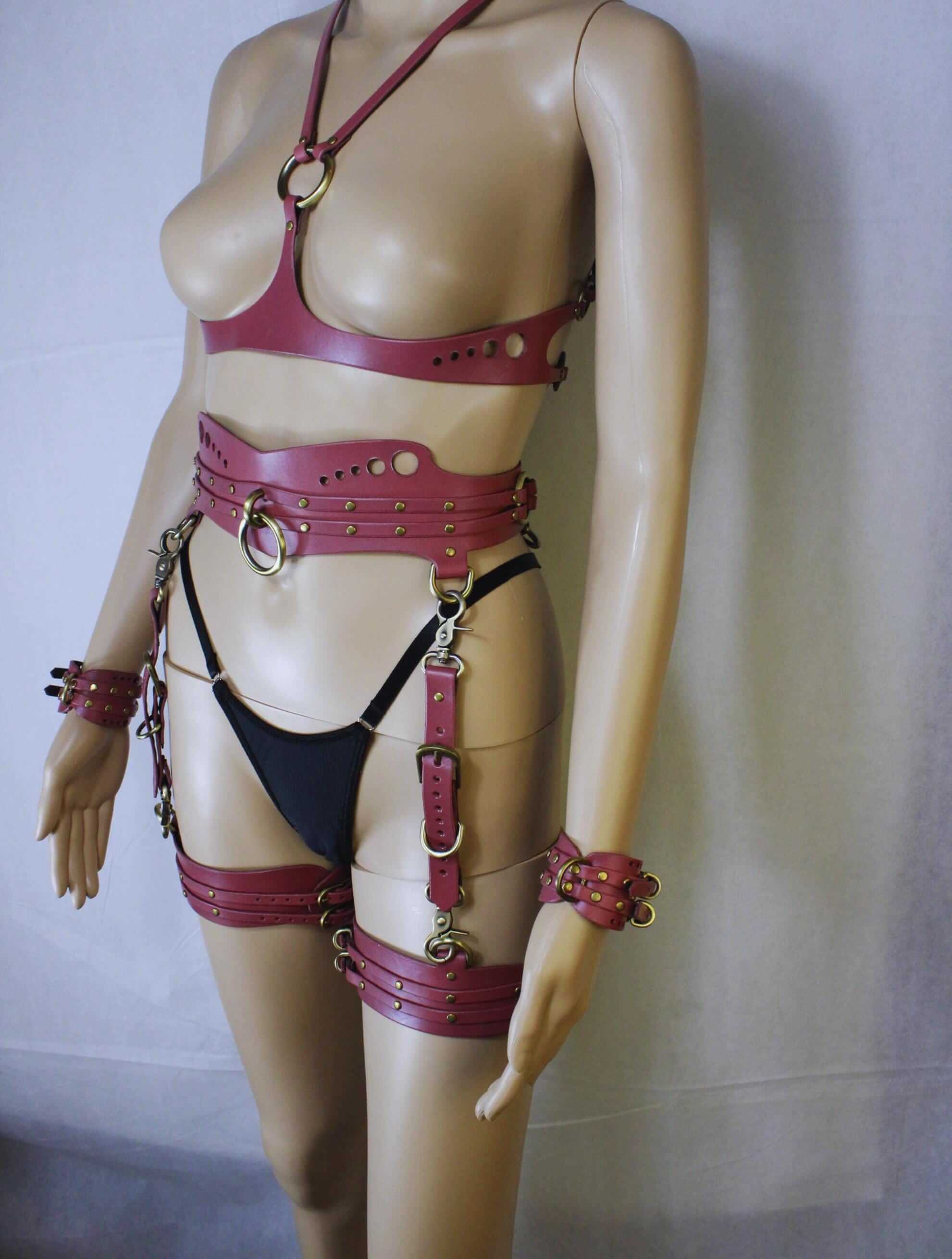 Bondage harness gear in mauve tone, featuring leather body harness, cuffs, and bondage accessories for BDSM enthusiasts.