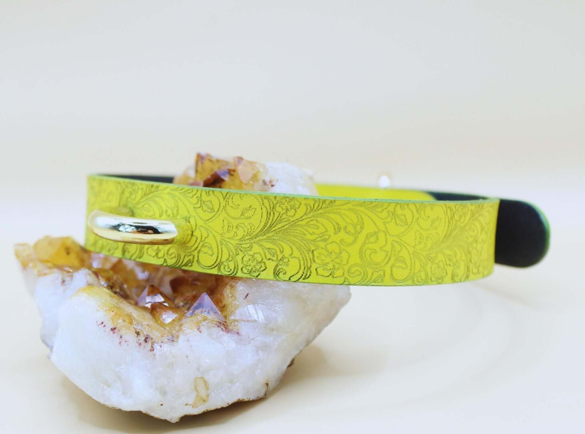 Yellow floral leather BDSM collar on a crystal, perfect for submissive jewelry and day wear.